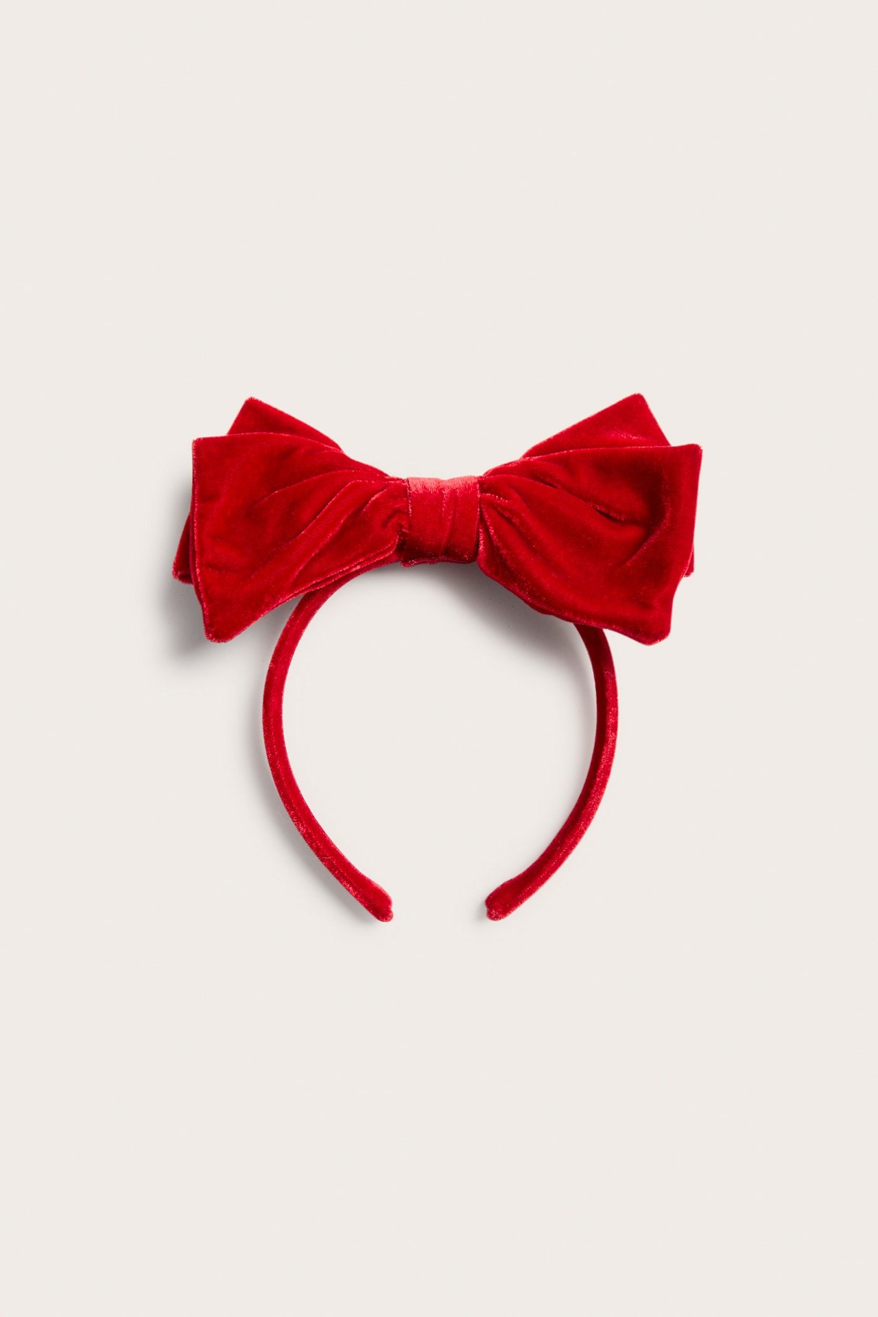 Frontvy av ett rött sammetsdiadem med en stor rosett på toppen.