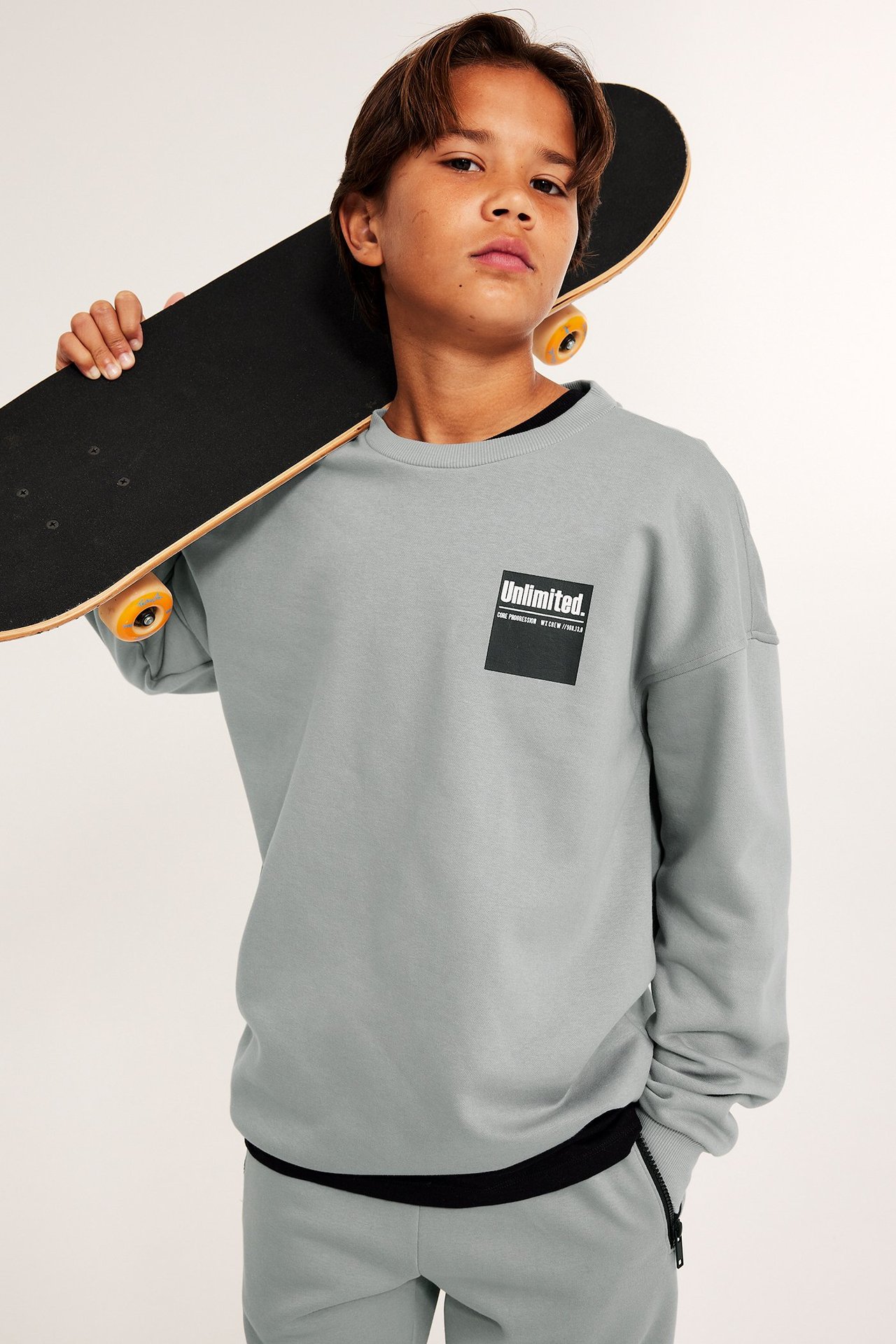 Szara bluza dla dzieci z nadrukiem z przodu, chłopiec z deskorolką.