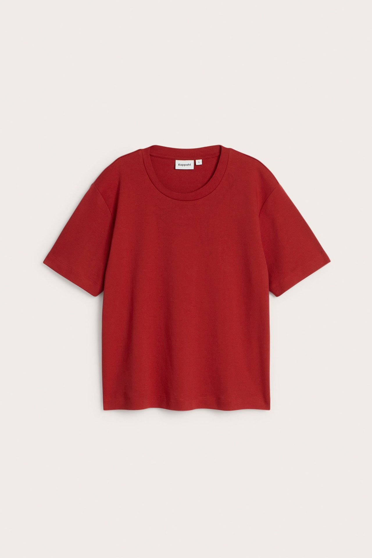 Frontvisning av en ensfarget rød oversized bomulls-t-skjorte med korte ermer og rund hals.