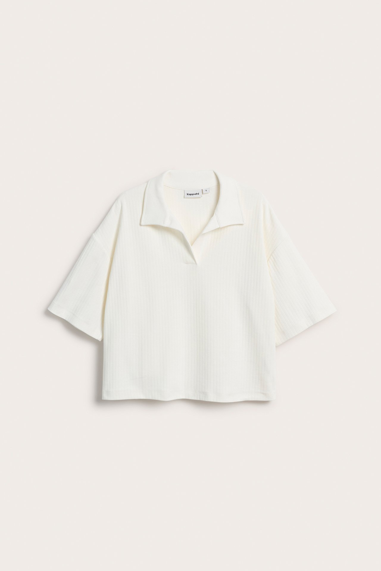 Framifrån, offwhite boxig kortärmad topp med krage och strukturerat tyg.