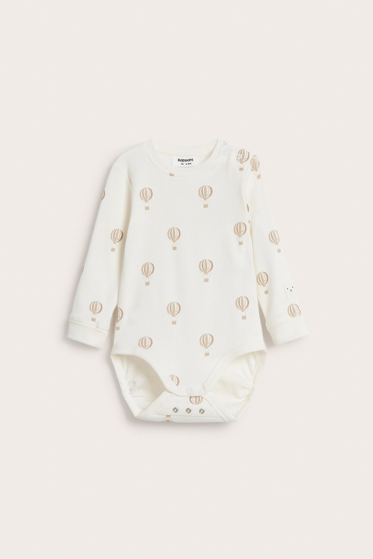 Frontvy av en beige ribbad babybody med långa ärmar, rund hals och mönster av luftballonger.