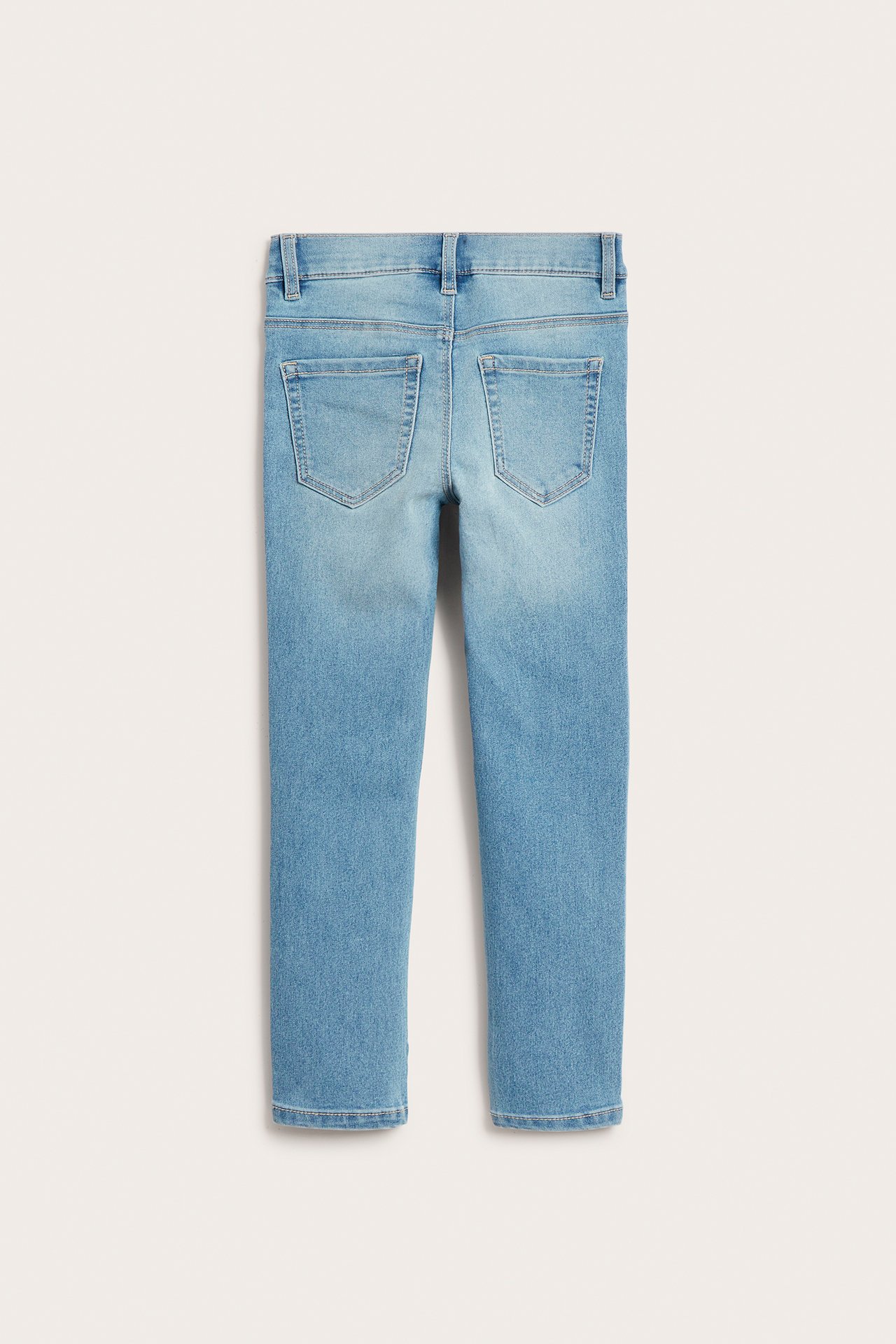 Widok z tyłu dziecięcych jasnoniebieskich jegginsów slim z dwiema tylnymi kieszeniami i szlufkami.