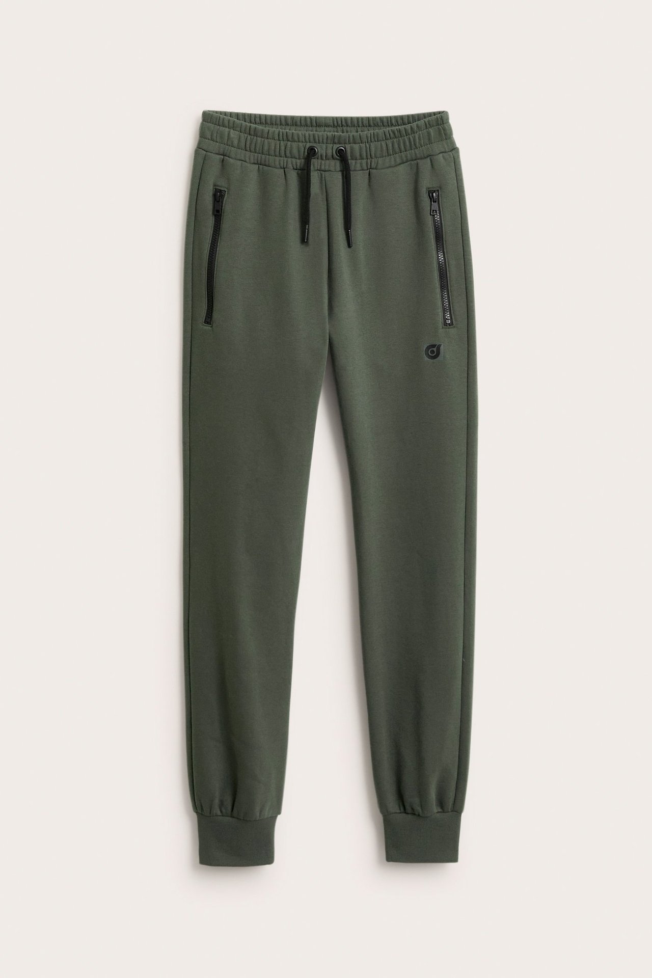 Widok z przodu: zielone dresy z bawełny i polaru, z czarnymi zamkami, sznurkiem i małym nadrukiem.