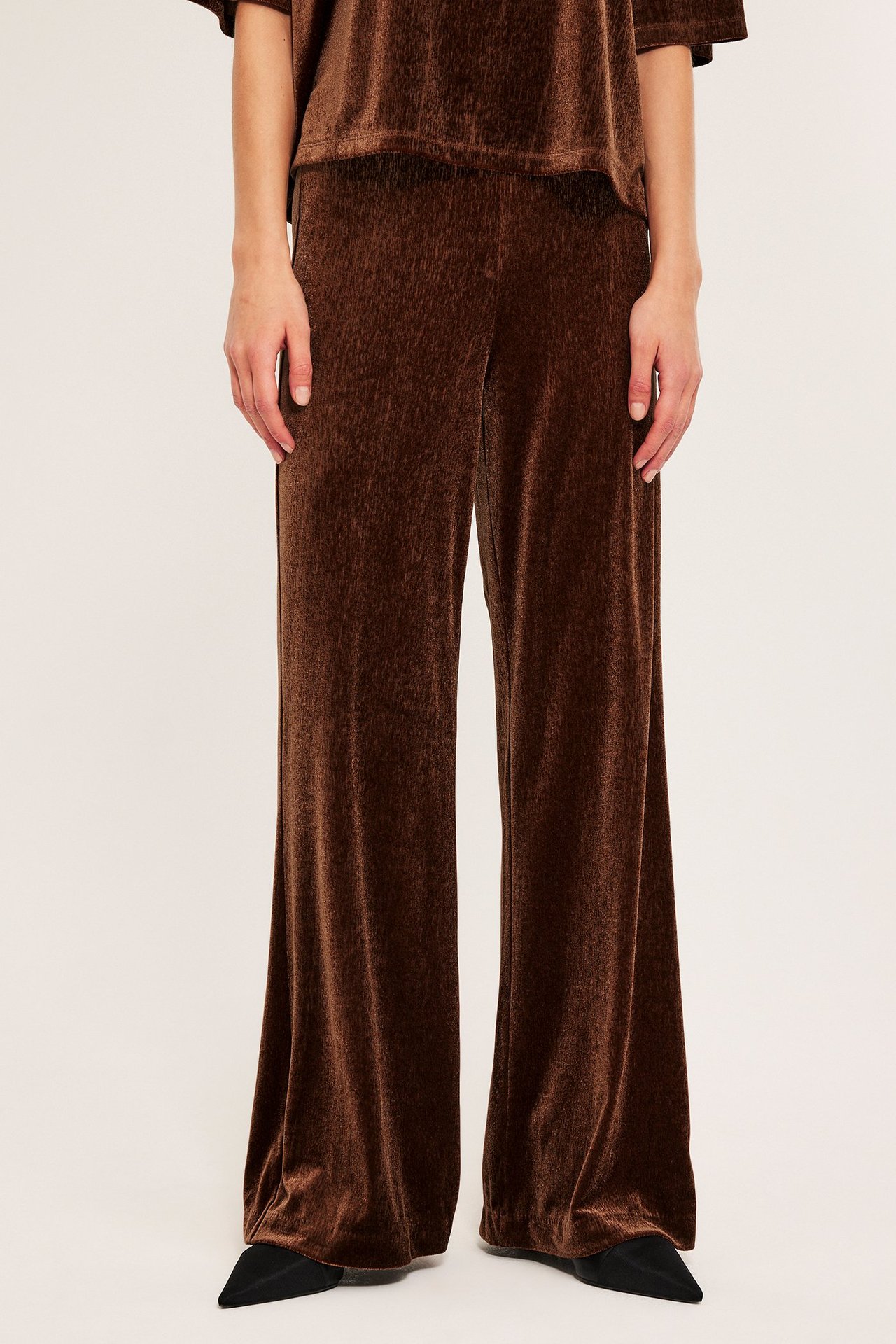 Brune velourjerseypantser med brede ben, helfigurvisning.
