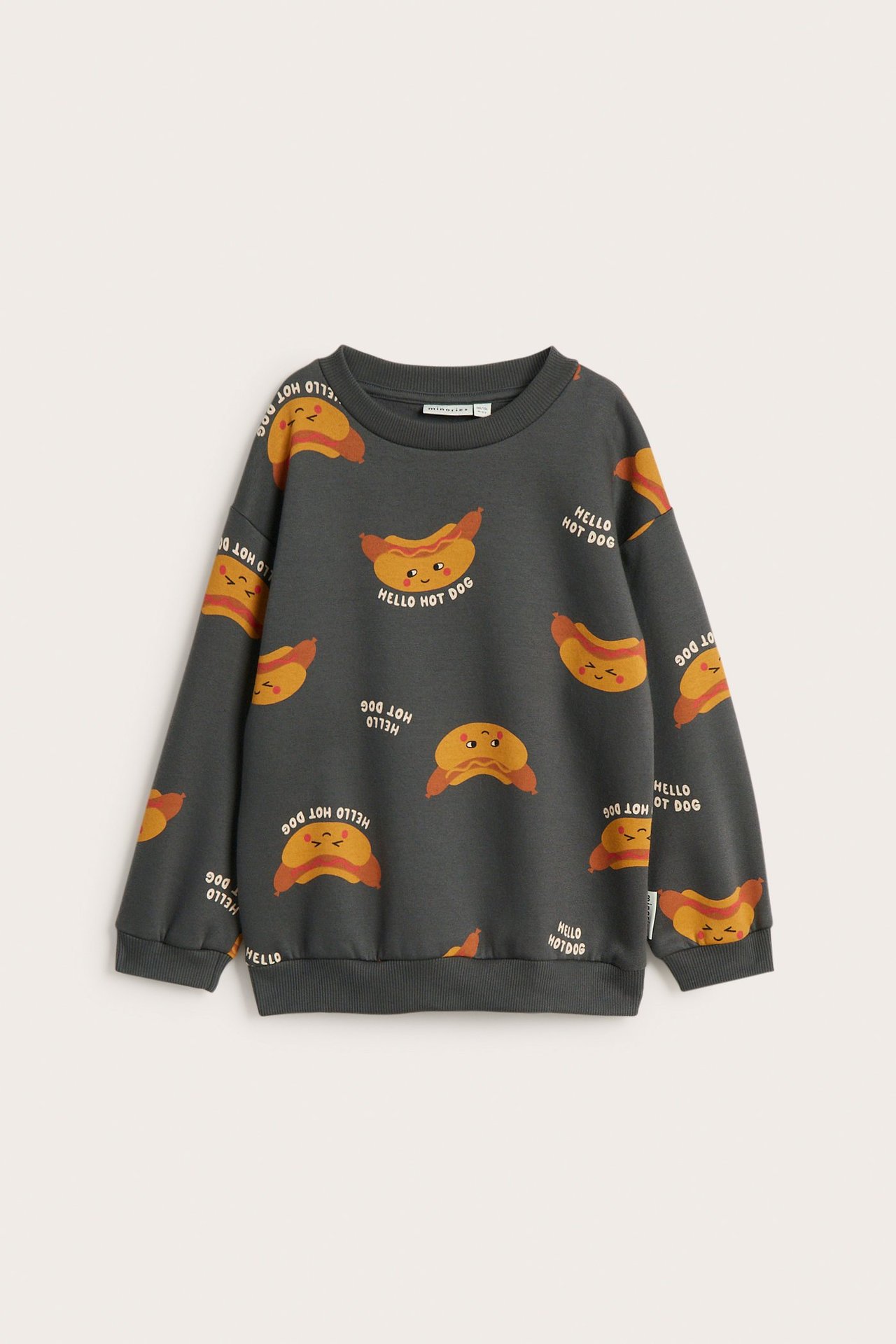 Frontbilde av en mørkegrå bomullssweatshirt for barn med gjentagende pølsemønster og tekst.