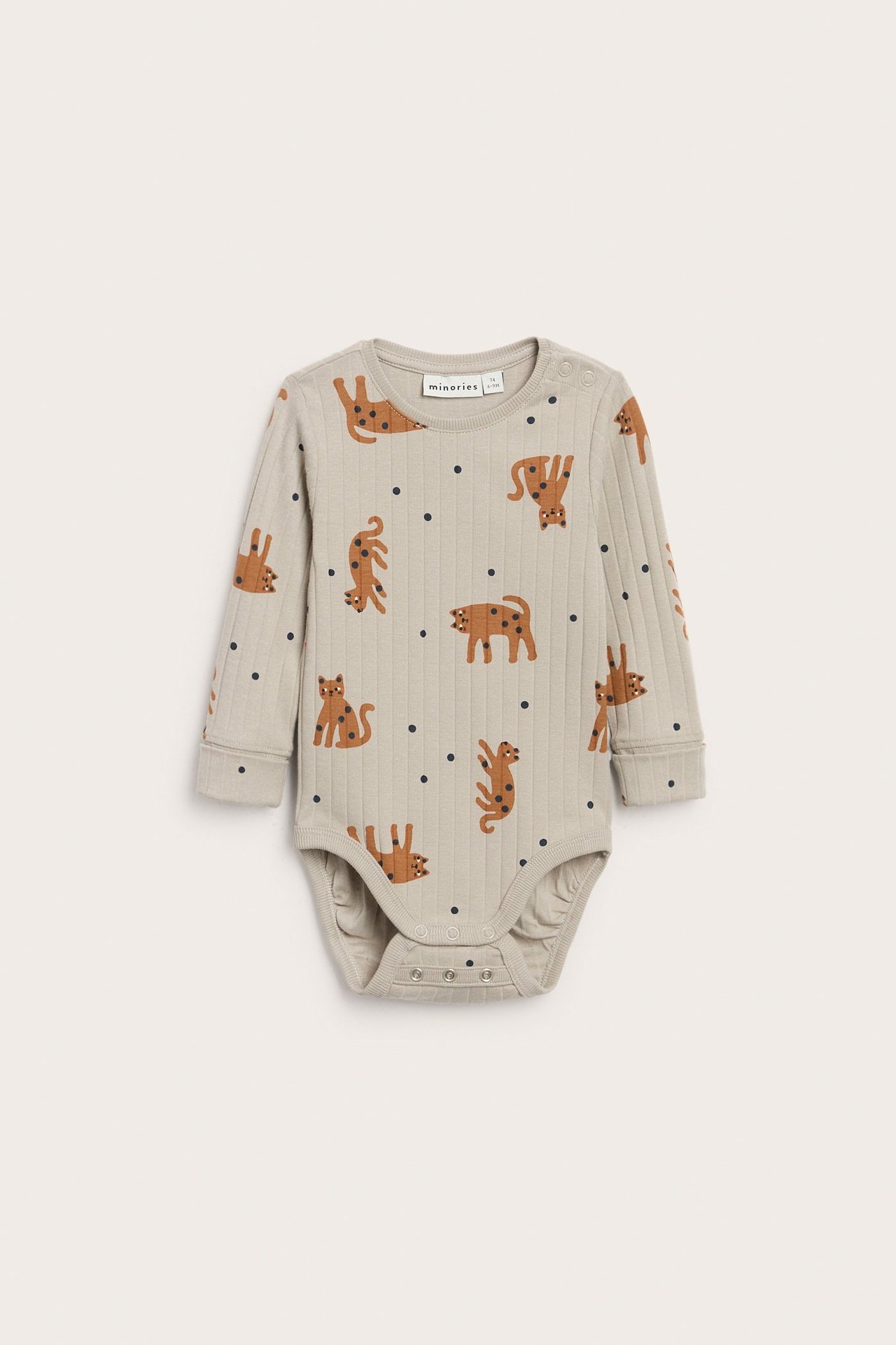 Framifrån: en beige ribbad babybody med brunt djurmönster och tryckknappar.