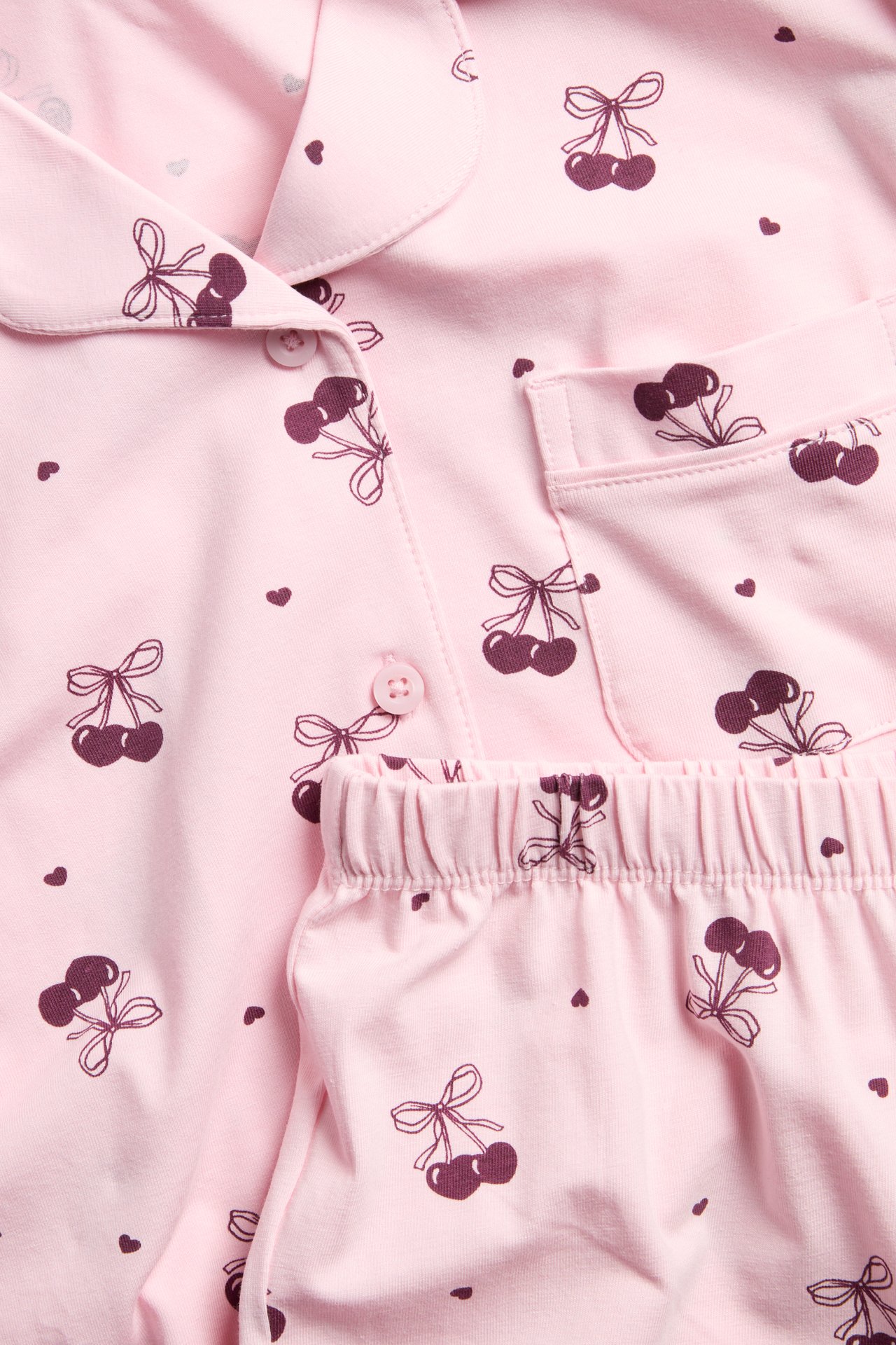 Vaaleanpunaiset trikoo-pyjamat kirsikkamustilla, lastenmalli, etunäytös.