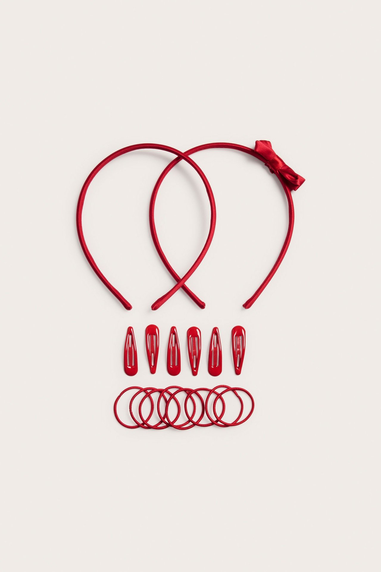 Widok z góry: dwa czerwone diademy (jeden z kokardą), sześć czerwonych spinek i osiem gumek do włosów.