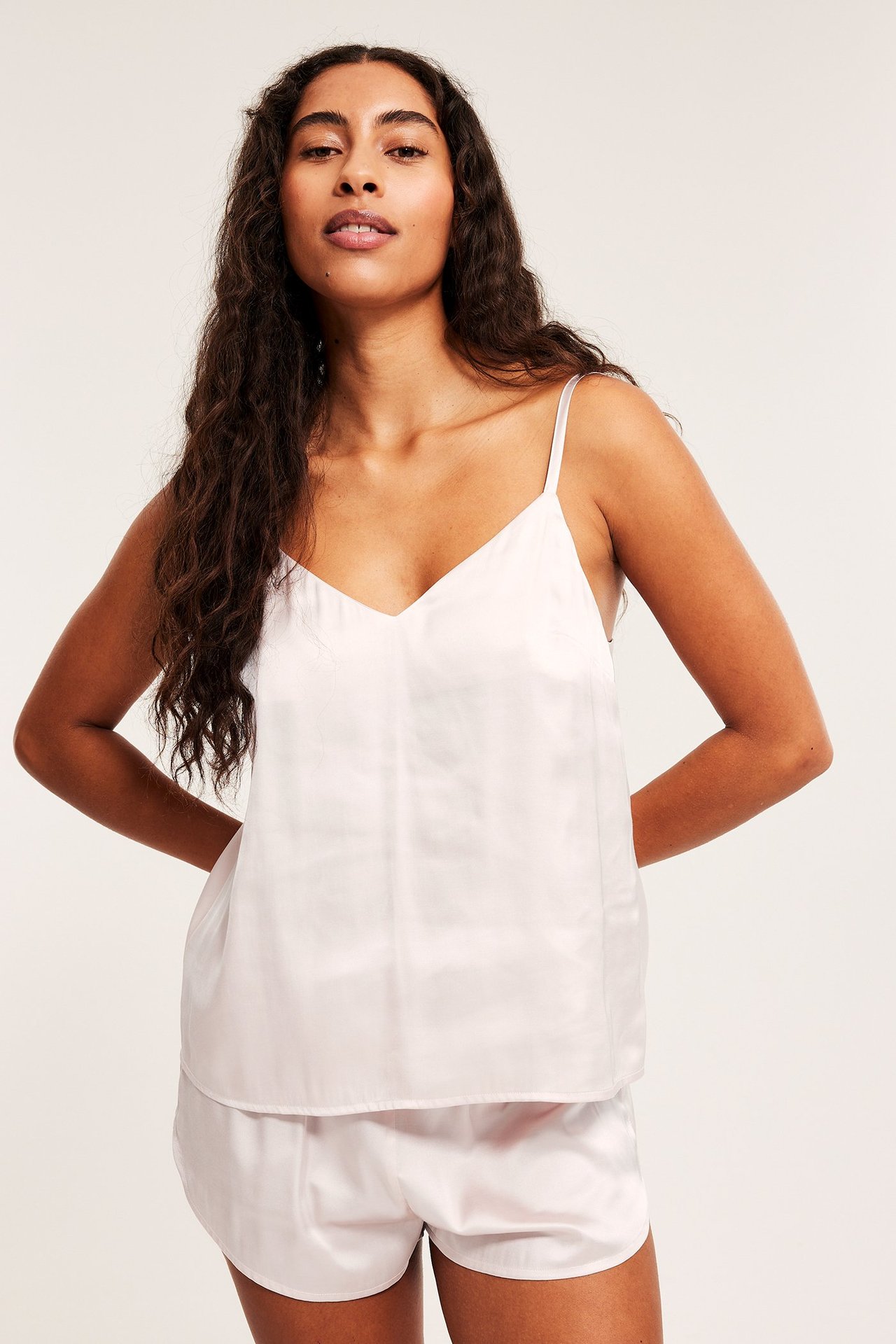 Różowa satynowa piżama z topem i spodenkami, jednolity materiał, model z przodu.