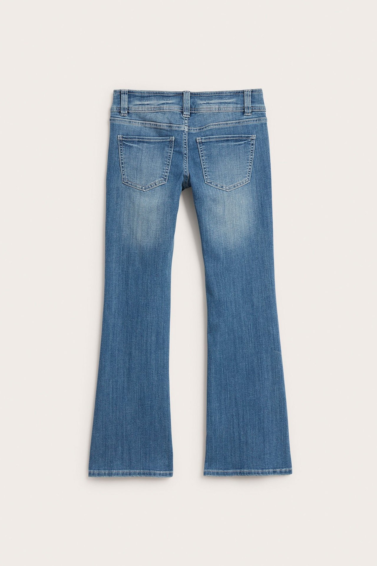 Widok z tyłu: jasne jeansy dżinsowe typu bootcut z niskim stanem, dopasowanym krojem i dwiema tylnymi kieszeniami.