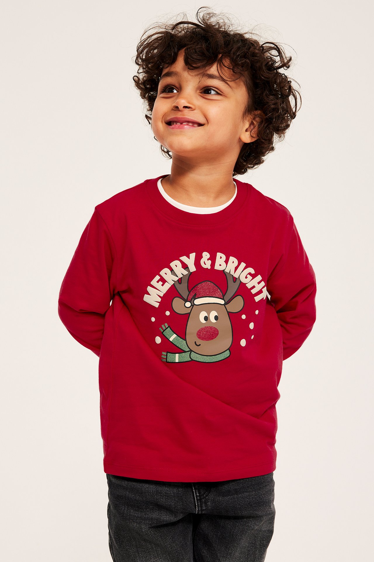 Gutt i rød langermet juletrøye med Rudolf-trykk, glitter og puff- effekt, front.