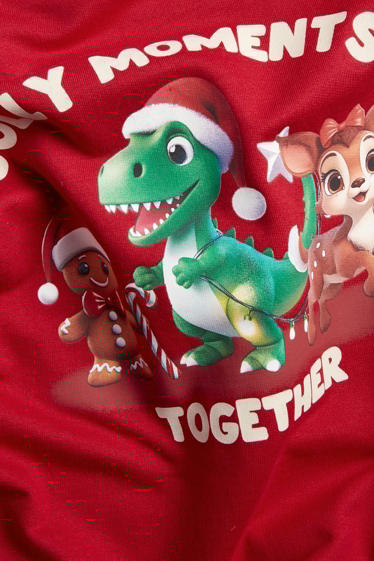 Zbliżenie: czerwona bluza z dinozaurem, piernikiem, sarną i napisem "MOMENTS TOGETHER".