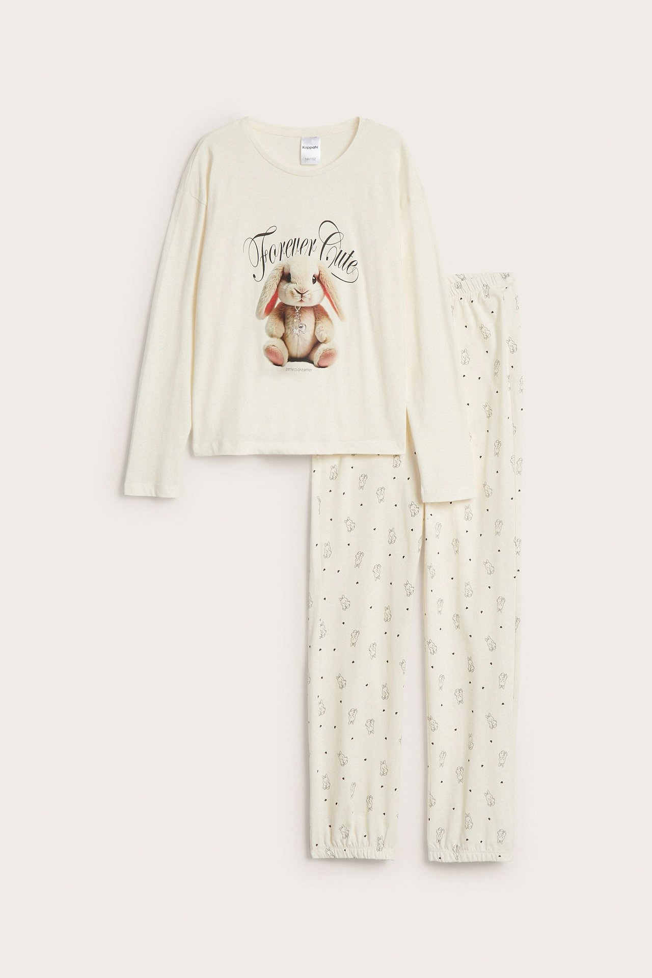 Frontvisning, en offwhite bomullspyjamas for barn med kanintrykk foran og mønstrede langbukser.