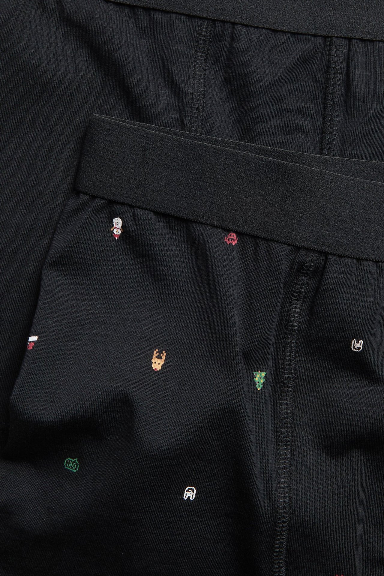 Zbliżenie na czarne bokserski dziecięce z motywami świątecznymi, obok gładkiej czarnej pary.