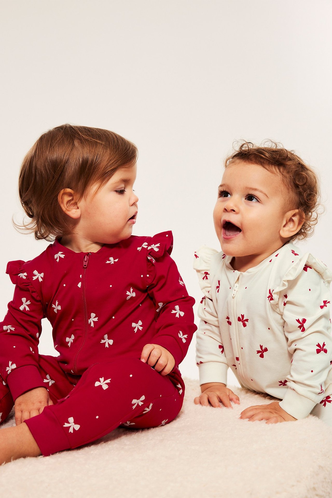 To-pack baby pysjamas med rosetter, rød og hvit, med frynser og 2-veis glidelås.