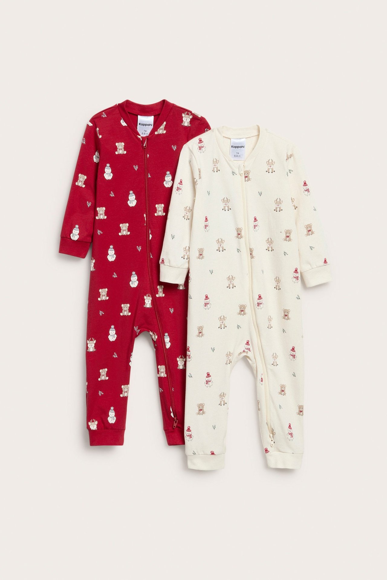 Frontalvisning av to babydresser: en off-white, en rød, begge med juletrykk og 2-veis glidelås.