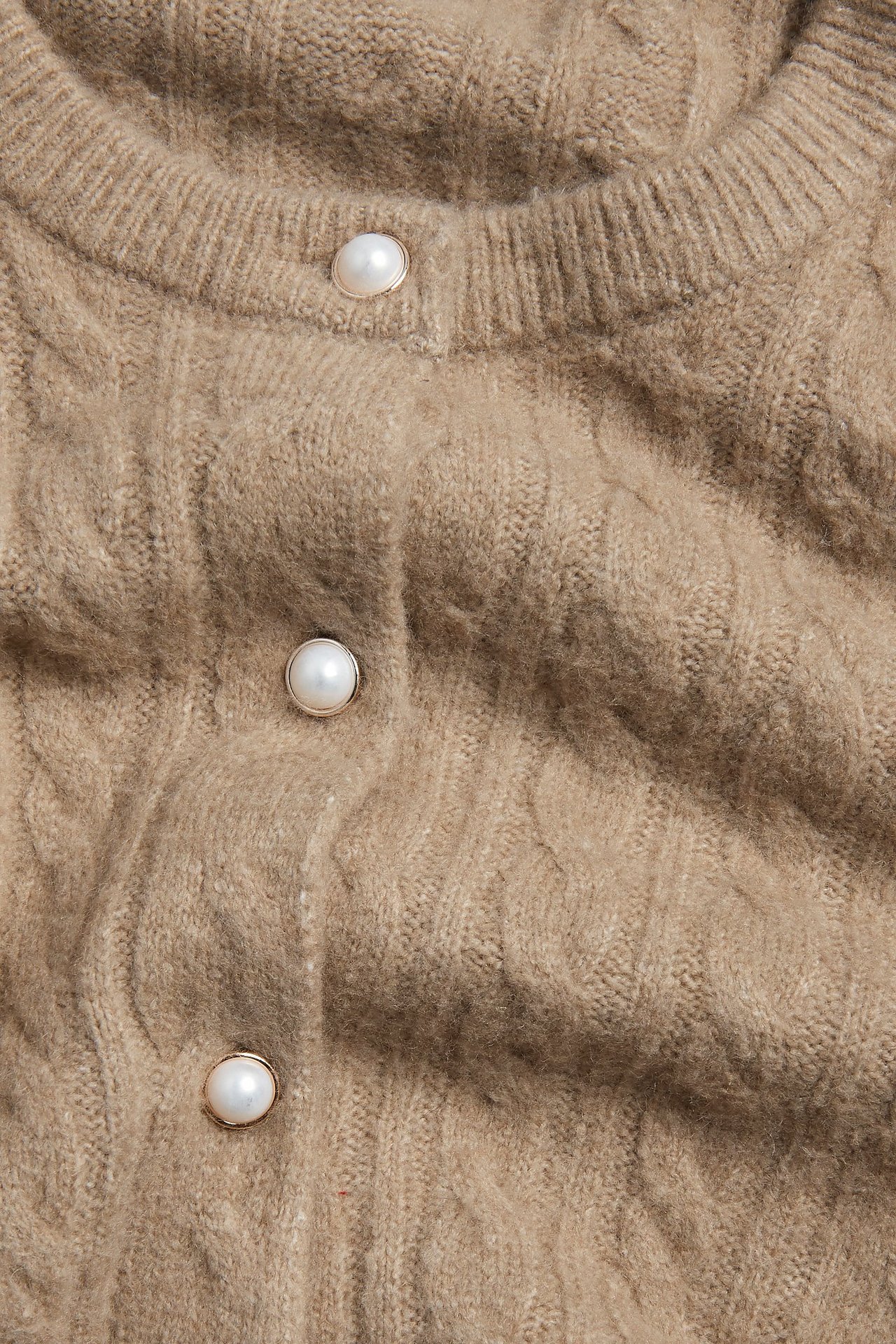 Widok z przodu, zbliżenie na ciemnobeżowy kardigan w warkoczowy splot z perłowymi guzikami.