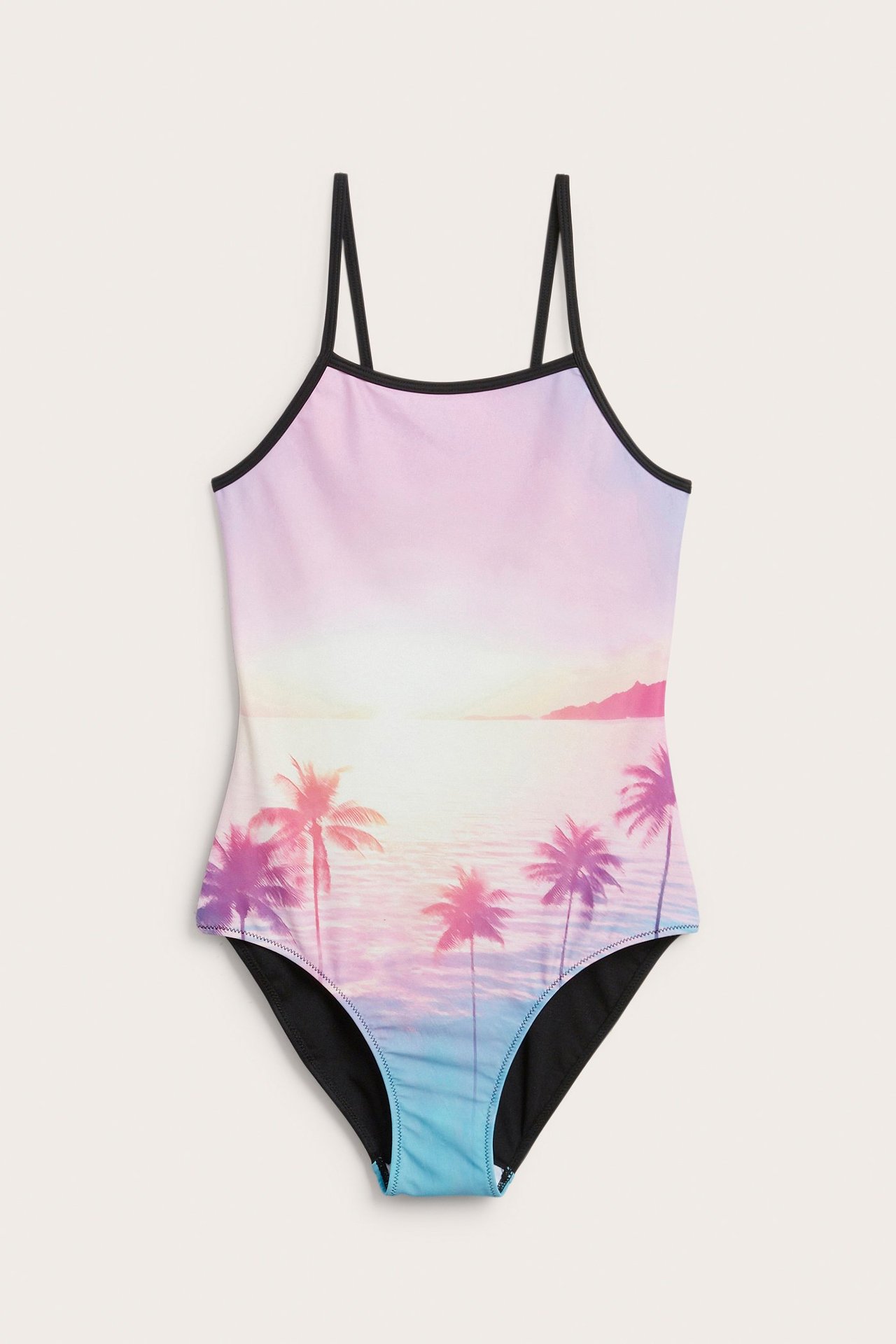 Edestä, lapsen vaaleanpunainen liukuvärjätty uimapuku, auringonlasku- ja palmupainatus, mustat olkaimet.