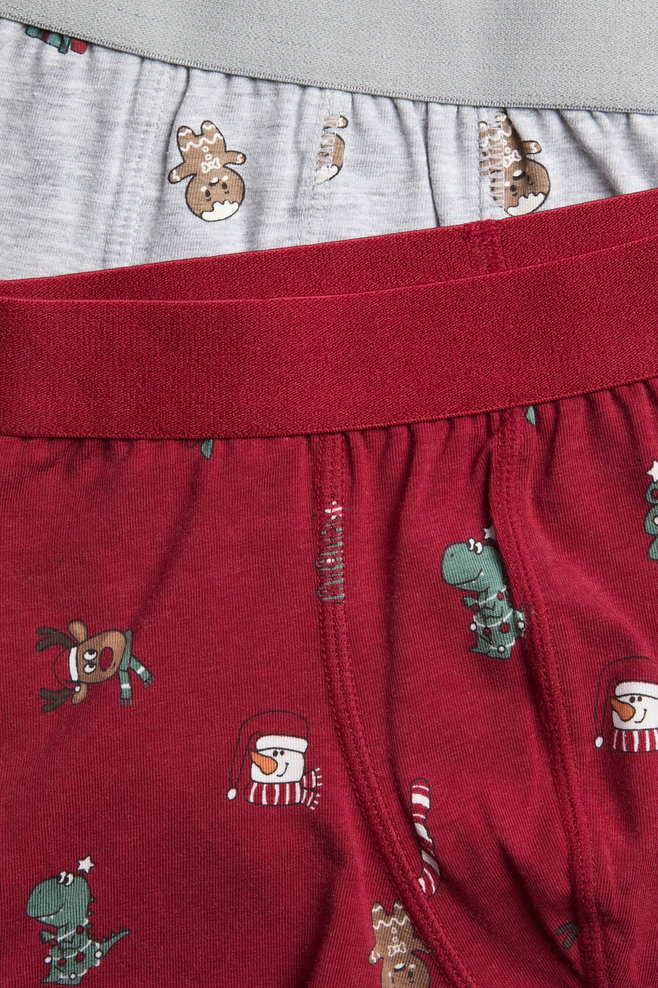 Zbliżenie na czerwone bokserki dziecięce z motywem świątecznym i szare ze wzorem pierniczków.