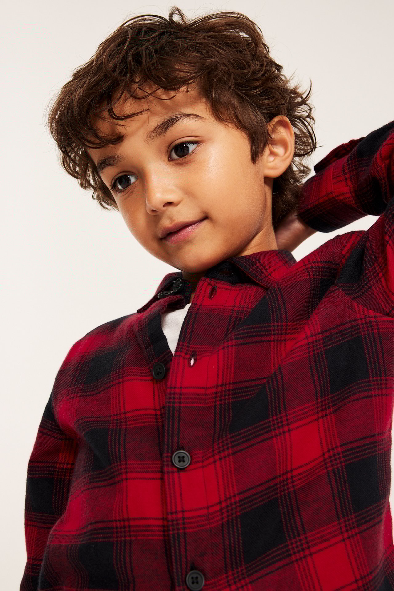 Poika punaisessa flanellipaidassa, pitkähihaisessa, edestä näkyvissä.