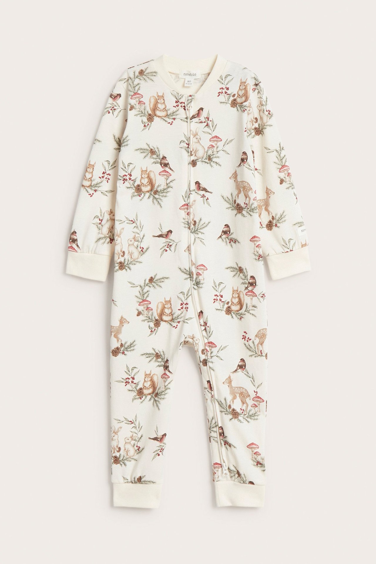 Frontvy av en offwhite babypyjamas med juligt djurmönster och tvåvägsdragkedja.