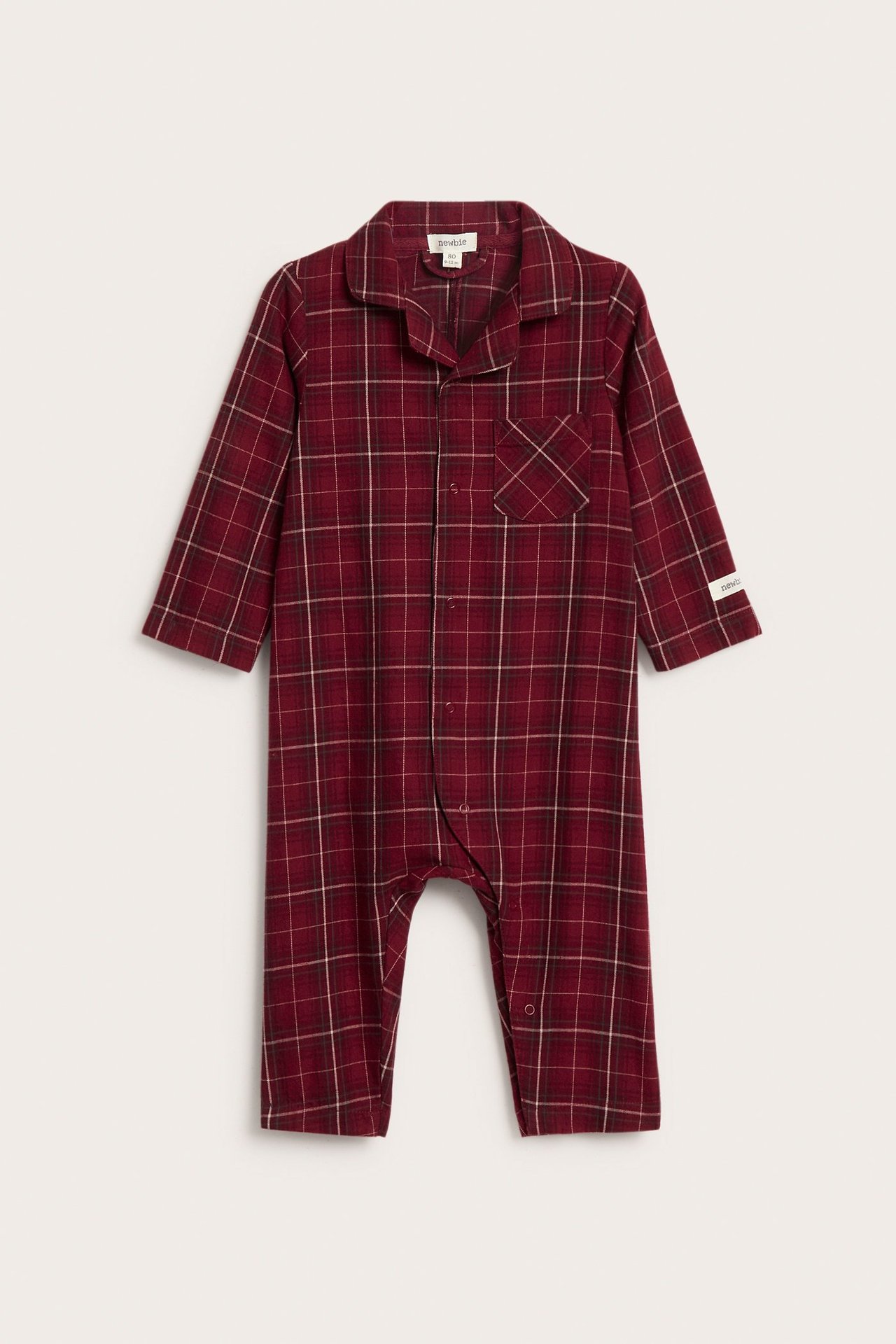 Frontvisning av en rød rutet baby-flanellpyjamas med lange ermer og trykknapper foran.