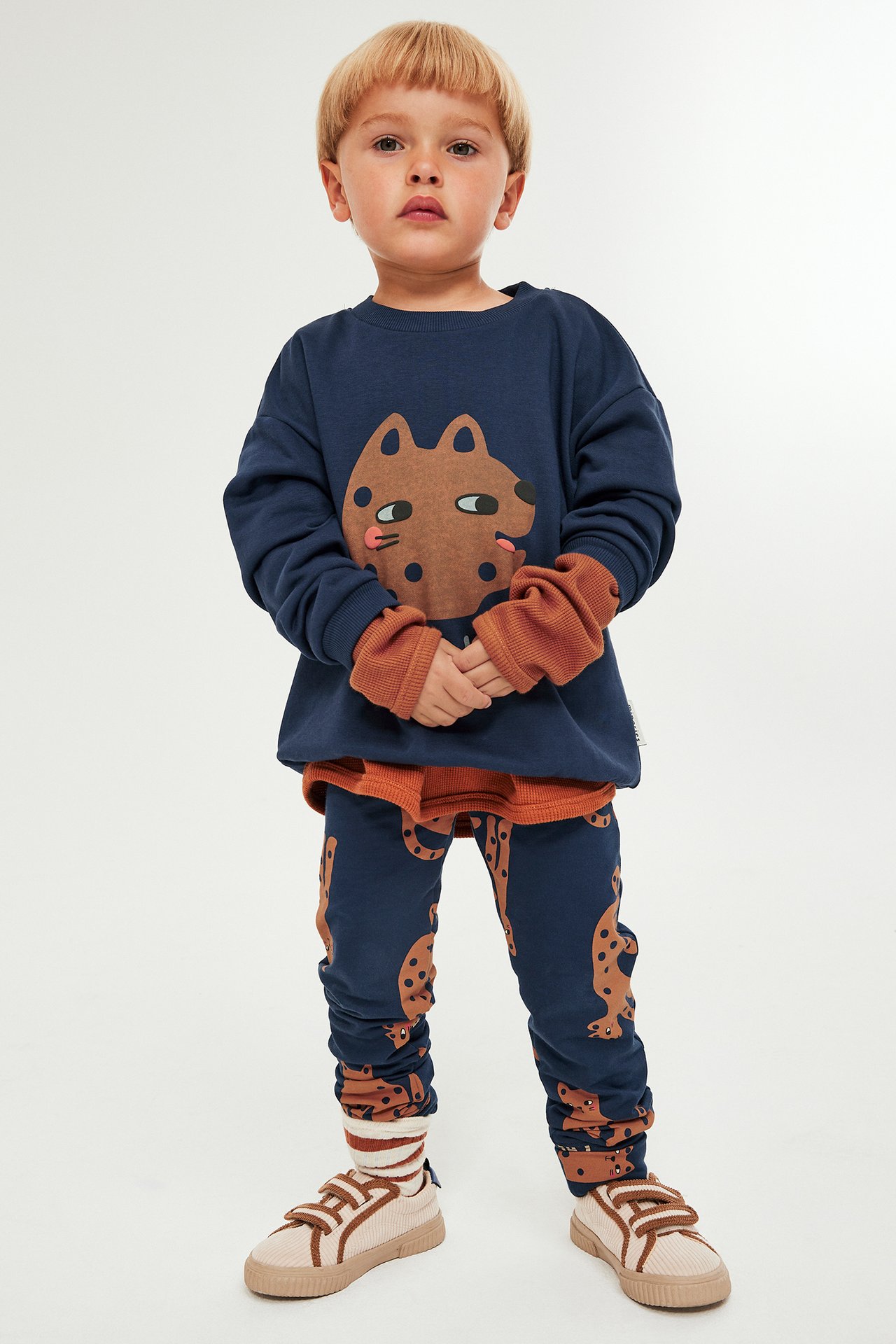 Gutt i blå sweatshirt med dyremønster og matchende bukser, frontvisning.