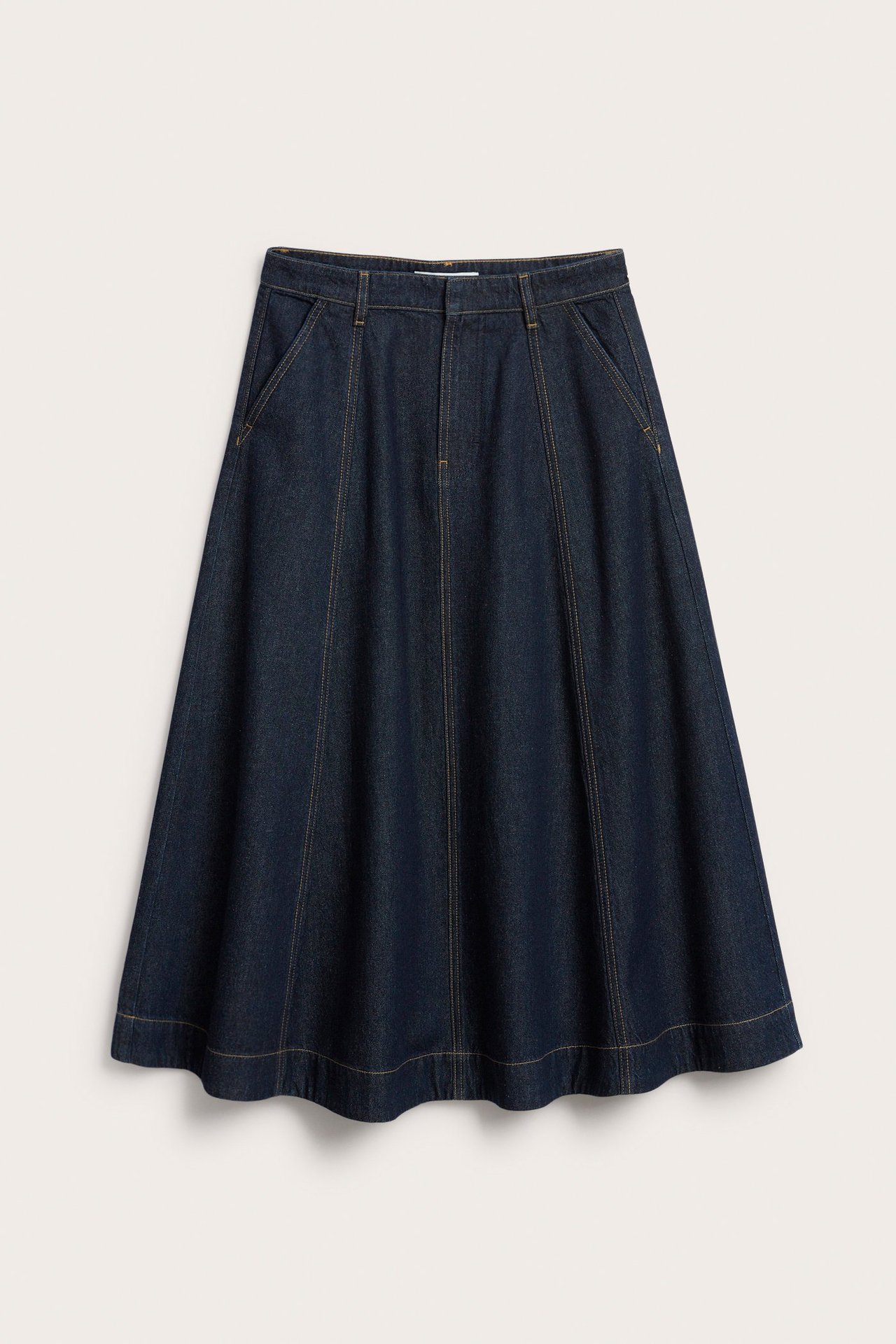 Frontvisning av et mørkeblått A-linje langt dongeriskjørt med sidelommer og lysebrune sømmer.