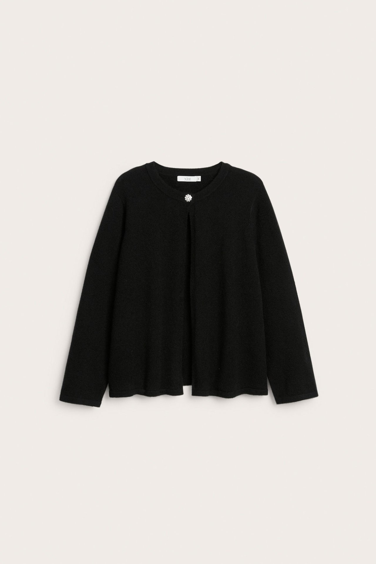 Musta naisten neuletakki pyöreällä pääntiellä ja yhdellä strassinapilla, edestä nähtynä.