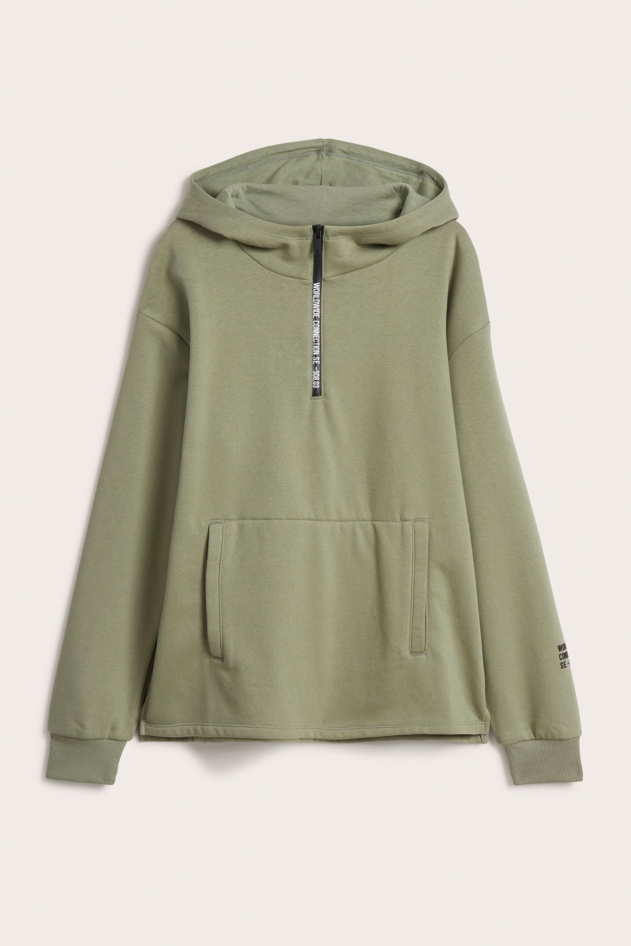 Framifrån: Enfärgad grön barnhoodie med huva, kort svart dragkedja med vit text och stor ficka fram.