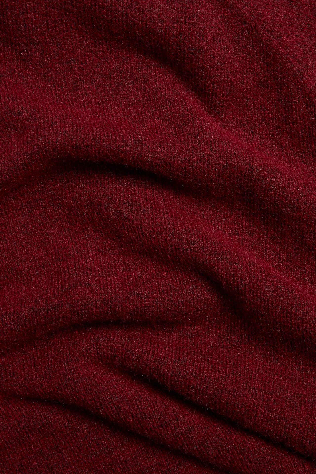 Zbliżenie miękkiego czerwonego melanżowego dzianinowego materiału z domieszką wełny z pulowera.
