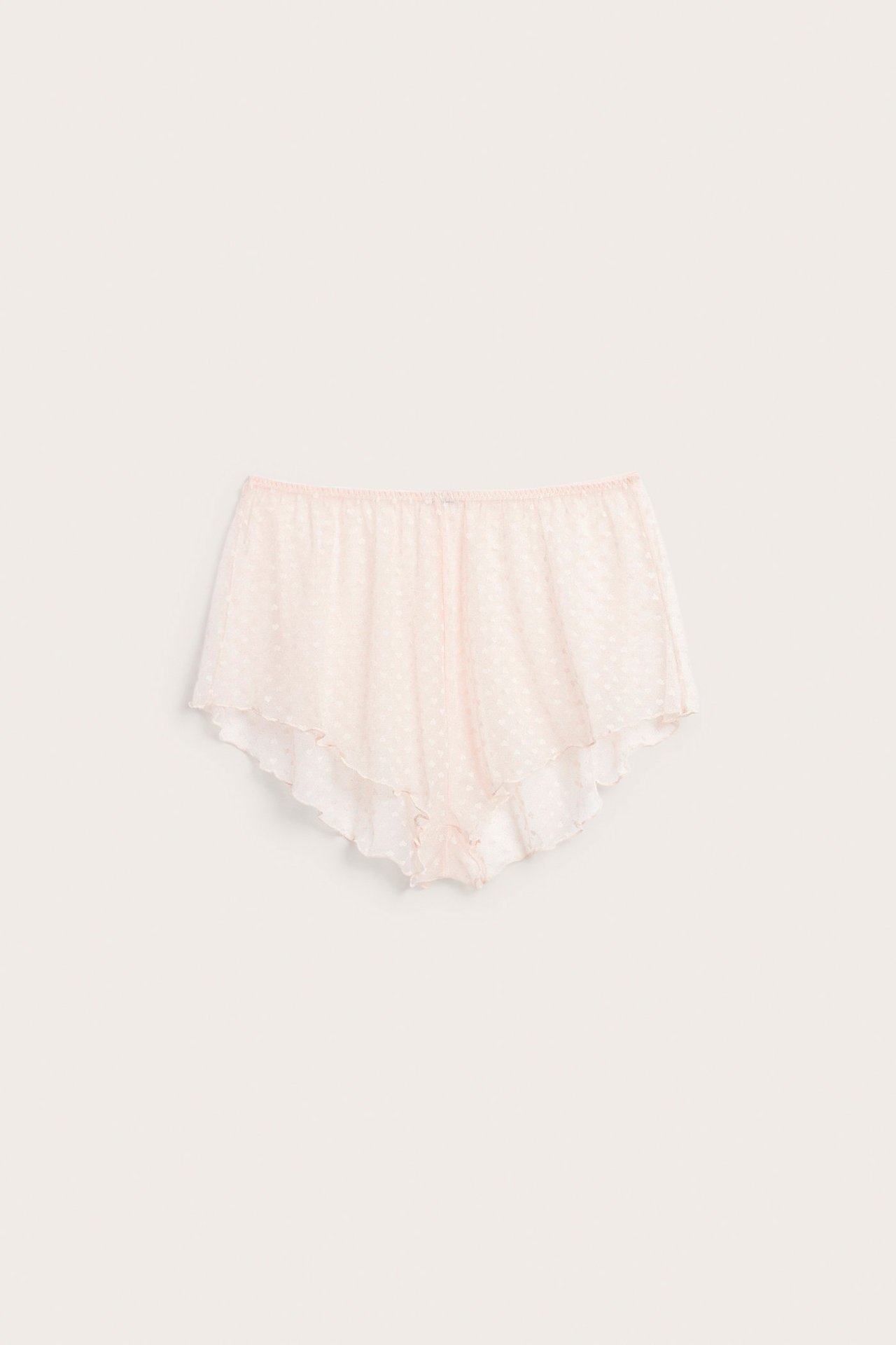 Frontbilde av lys rosa hjerte-mønstrede gjennomsiktige mesh shorts med volangkanter.