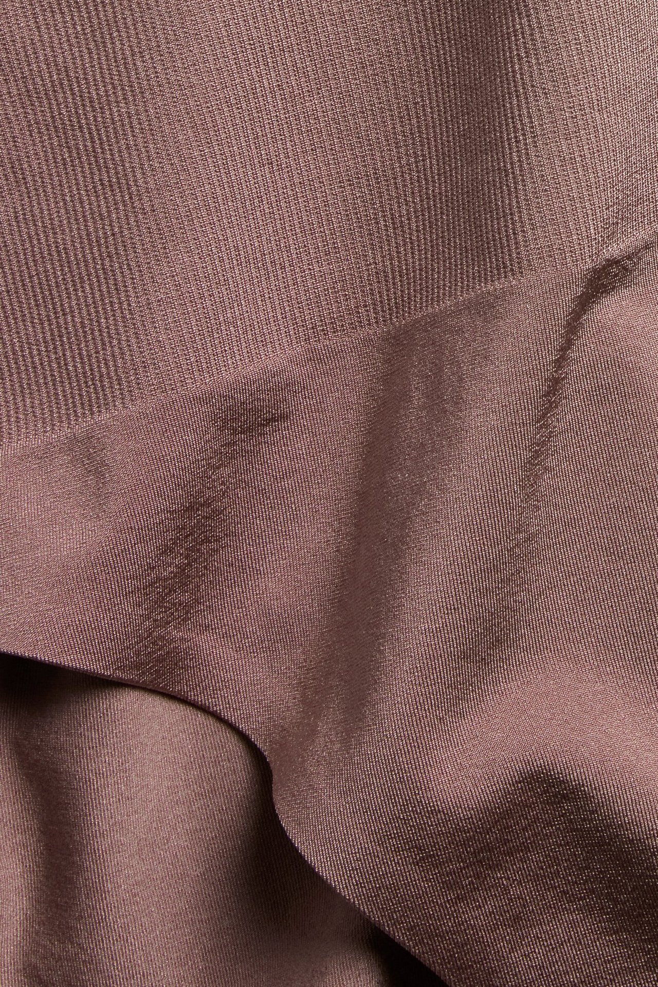 Nærbilde: Mørkerosa sømløst trusestoff med ribbete og glatte polyamid-elastan teksturer.