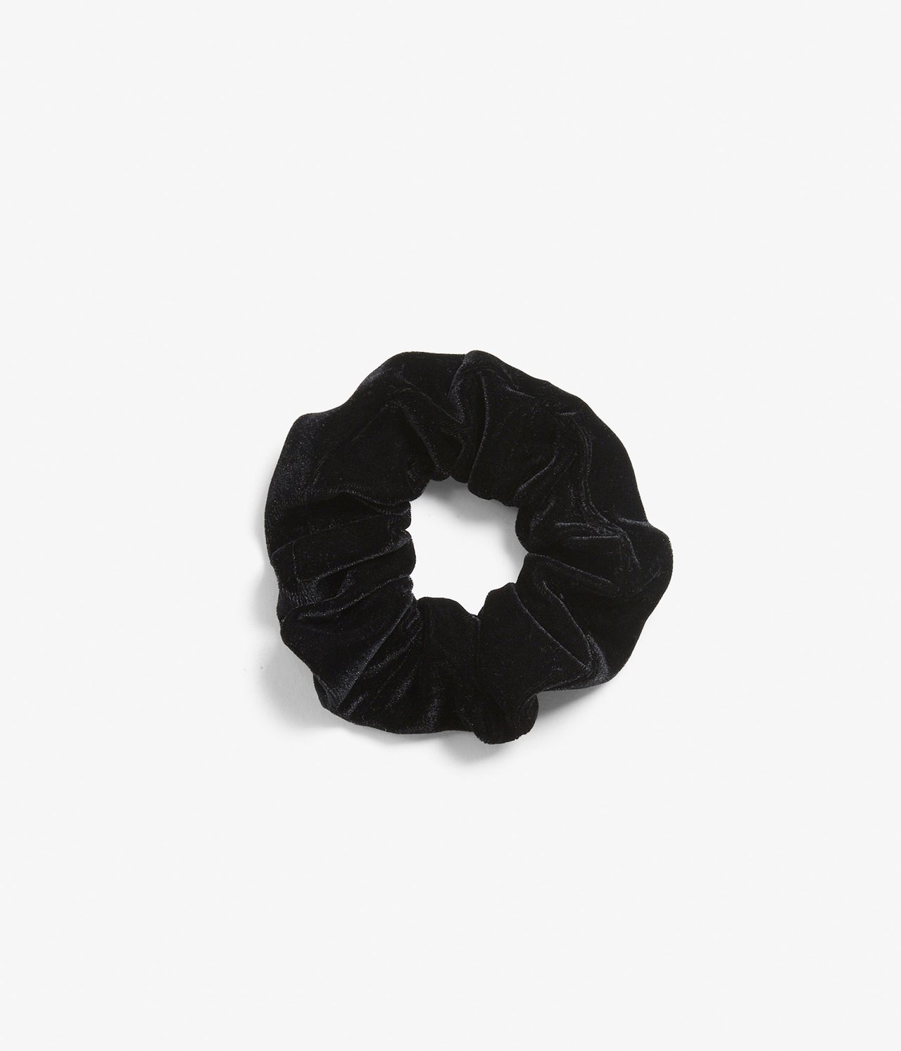 Ylhäältä kuvattu musta veluurinen scrunchie, rypytetty hiuslenkki.
