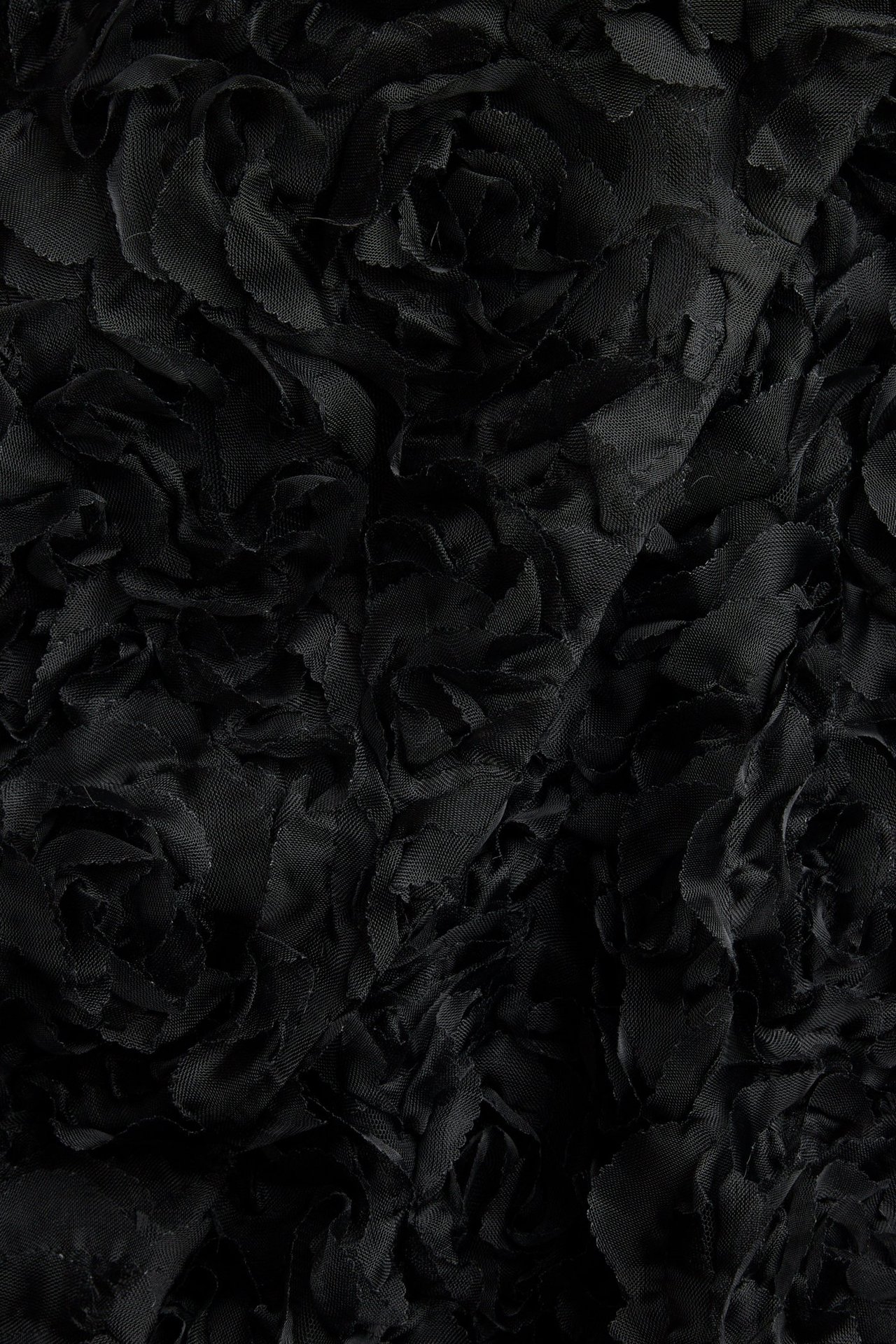 Zbliżenie na czarny materiał sukienki kopertowej z detalicznym wzorem kwiatowym 3D.