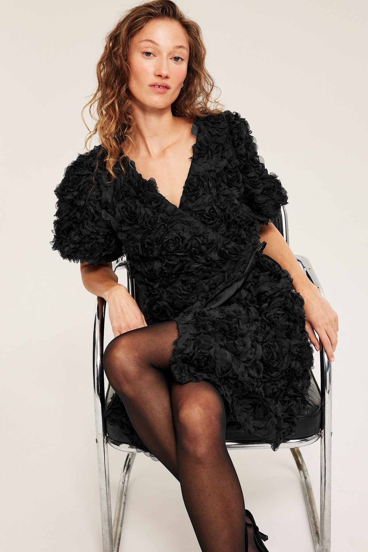 Czarna sukienka kopertowa z teksturą i wiązaniem w talii, krótki rękaw, kobieta, front.