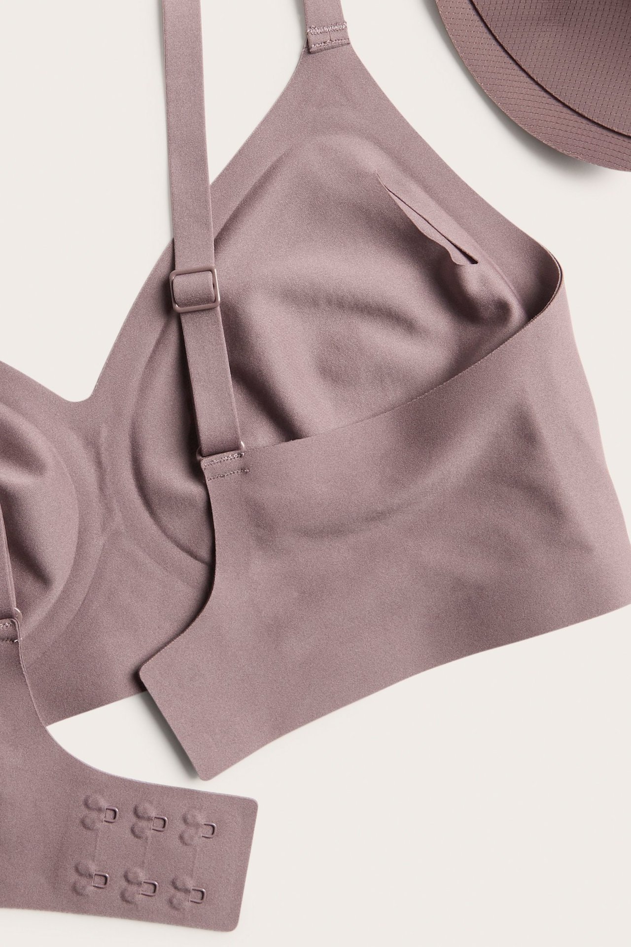 Närbild på en mörkrosa bygellös bh i micro med justerbara axelband och knäppning.