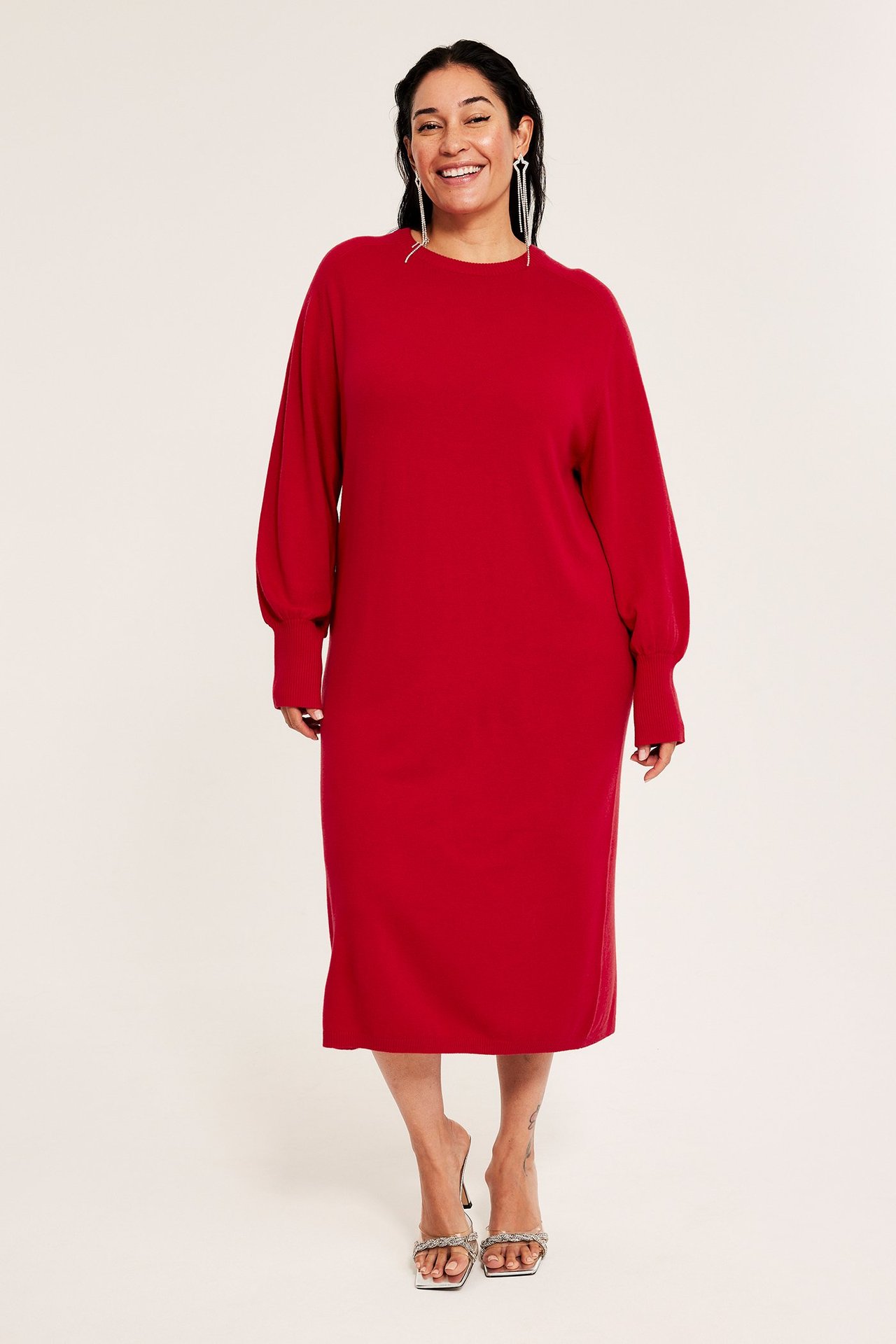 Röd stickad klänning för kvinna med puffärmar vid mudd, frontvy.