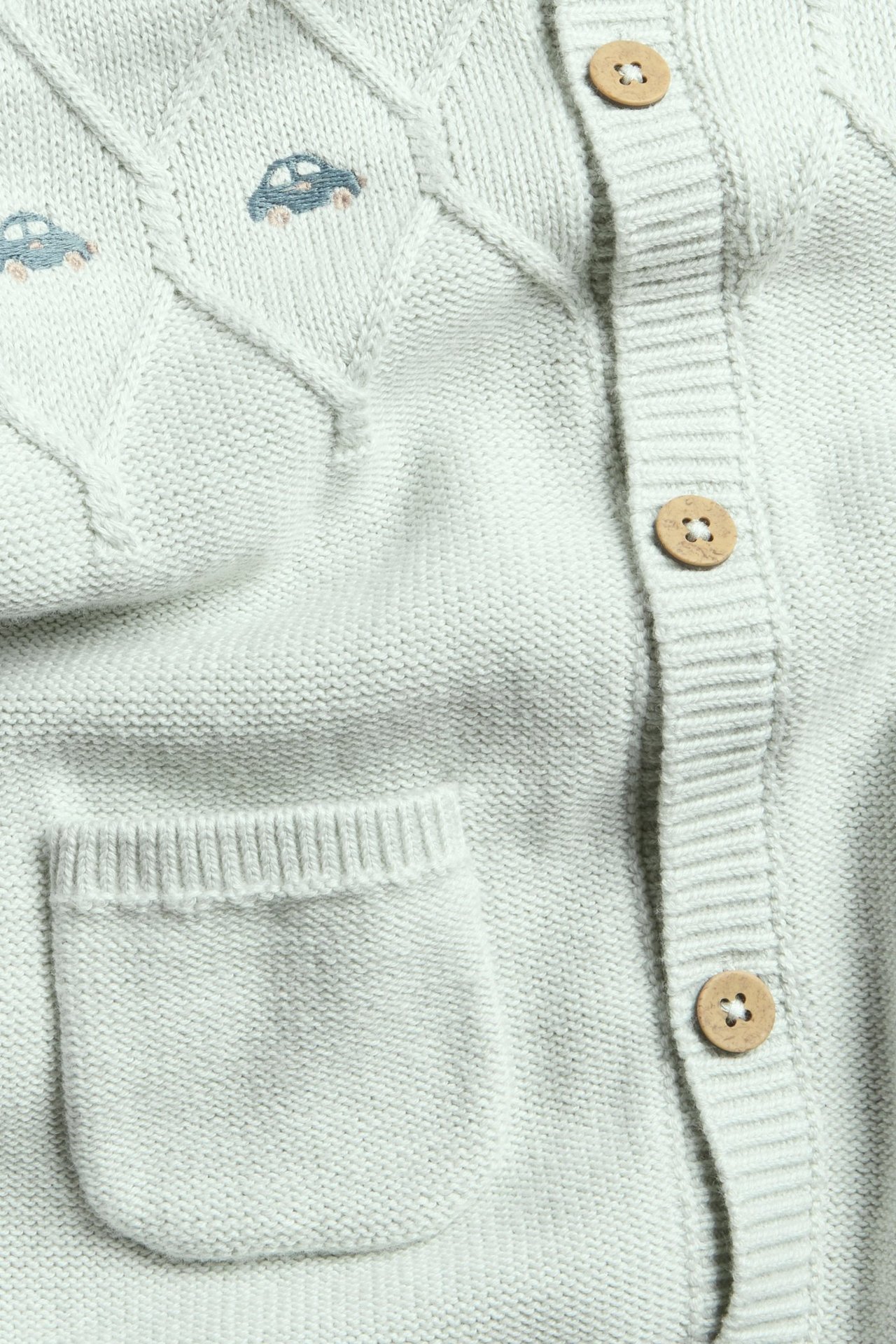 Lys turkis strukturstrikket jumpsuit for barn med broderi, knapper foran og ribb i hals og ermer.