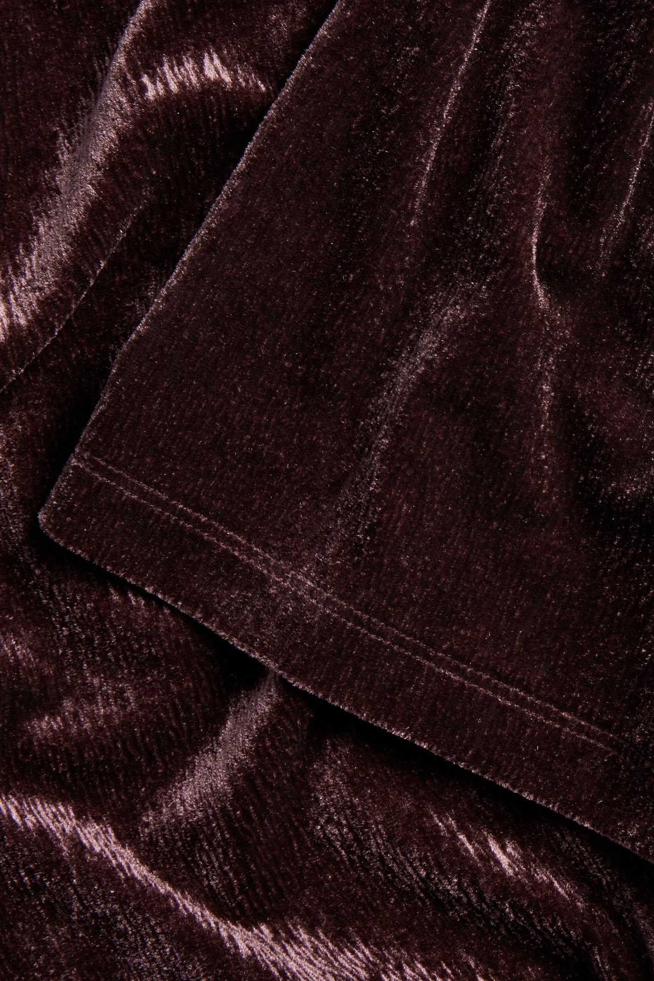 Zbliżenie na bordowy welur z krótkiego topu, ukazujące jego miękką teksturę.
