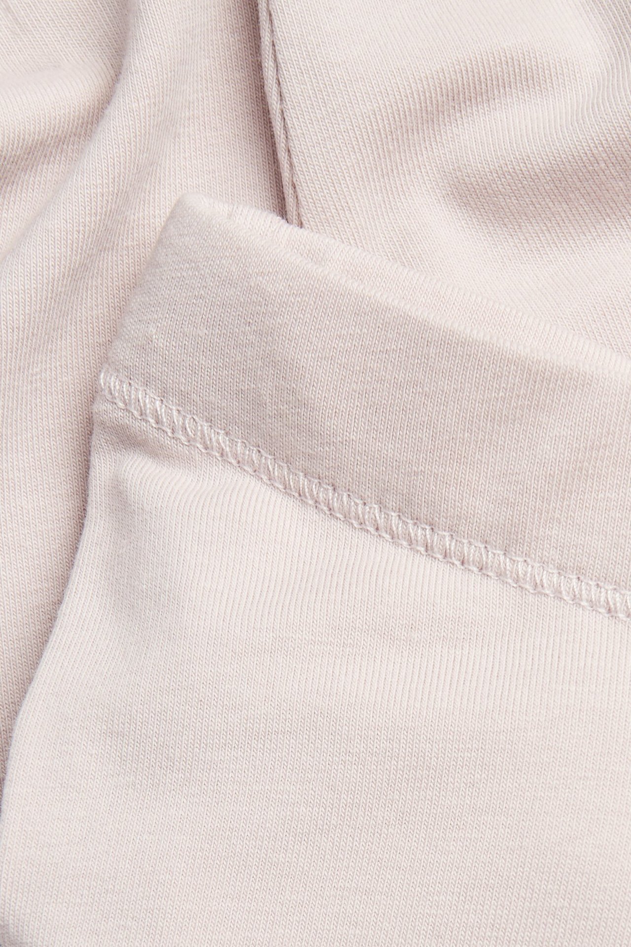 Närbild av ljuslila enfärgade ribbade leggings med resår i midjan.