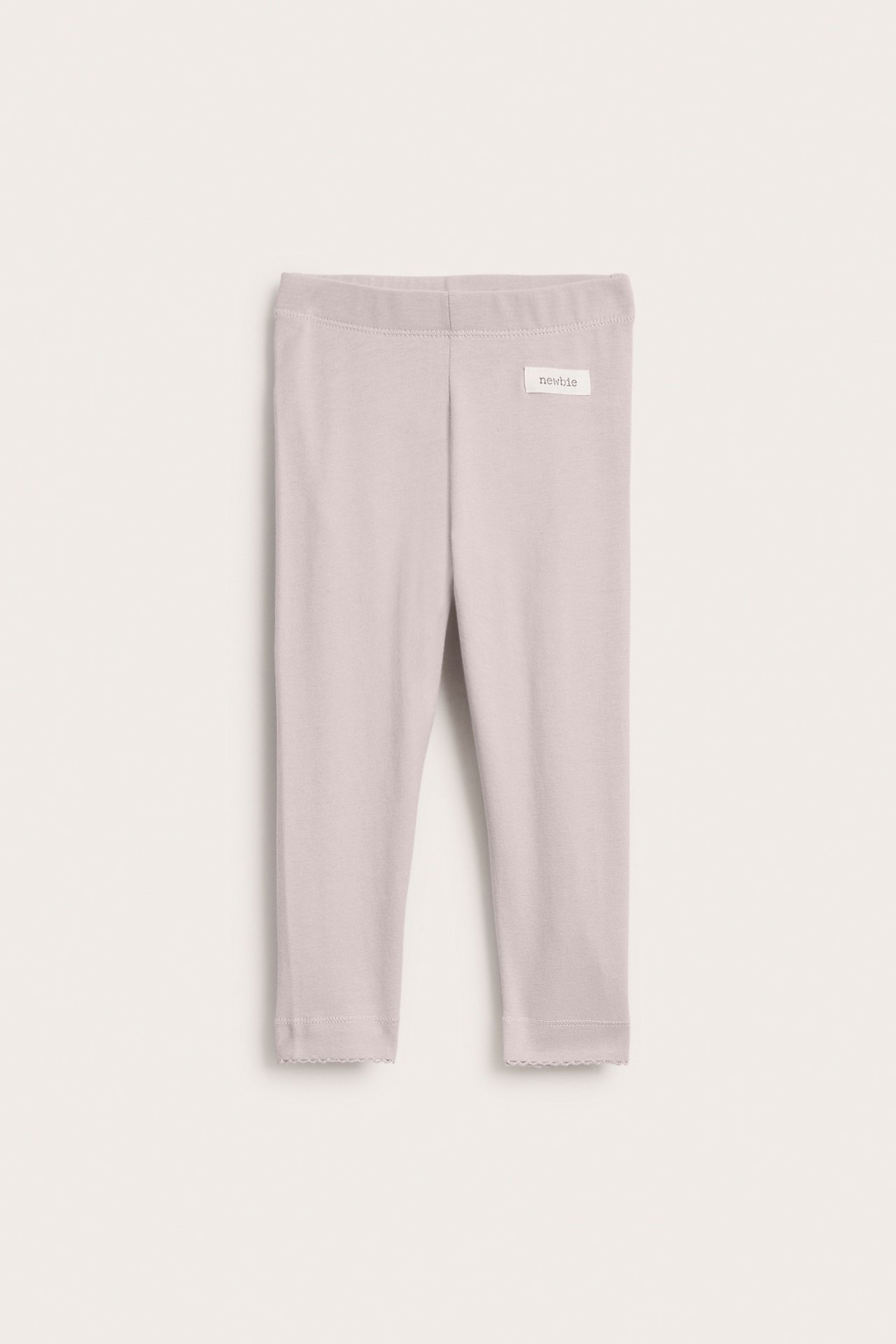 Framifrån, baby leggings i ljuslila med vågiga muddar.