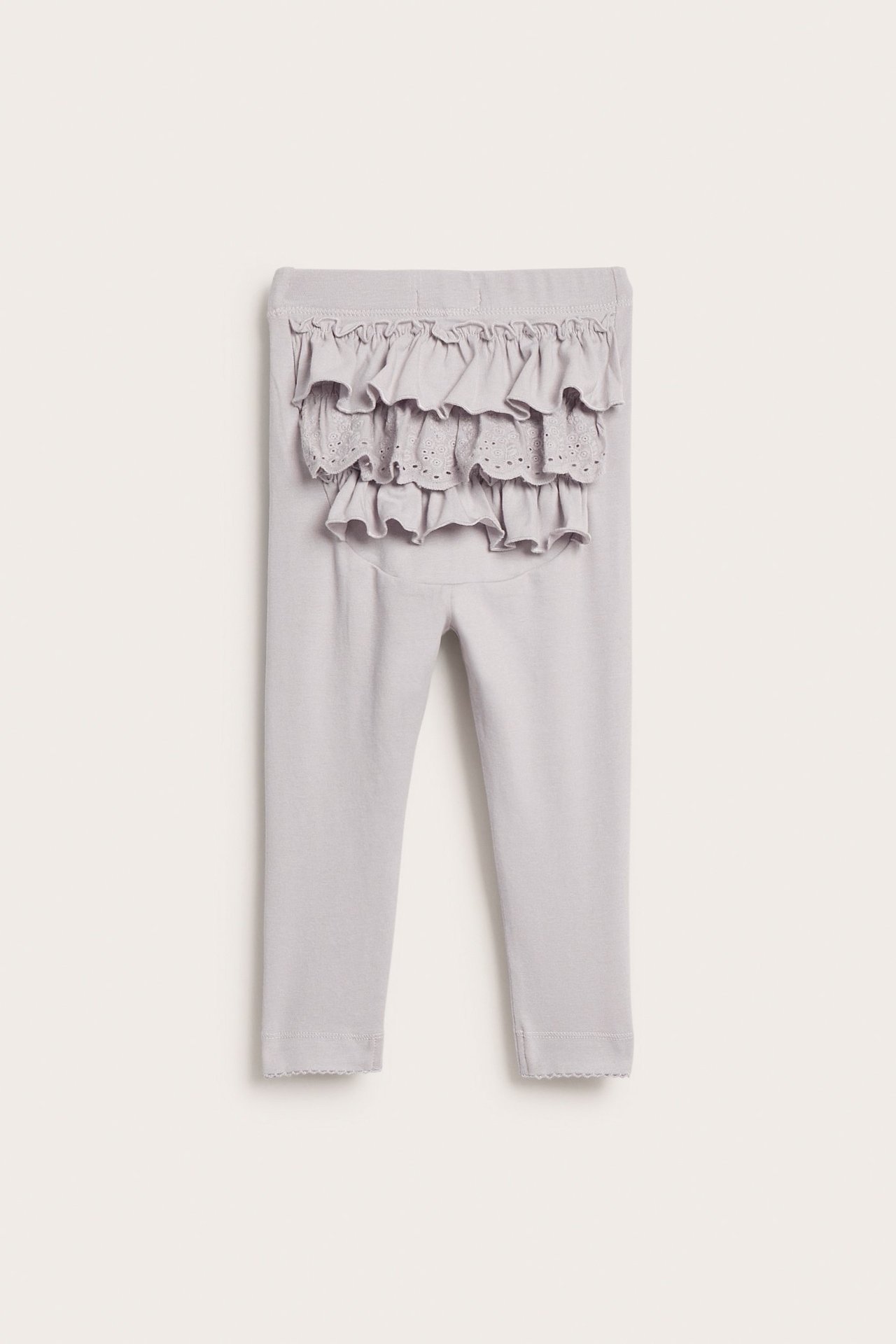 Sett bakfra: lys lilla baby leggings med rysjer og blondedetaljer.