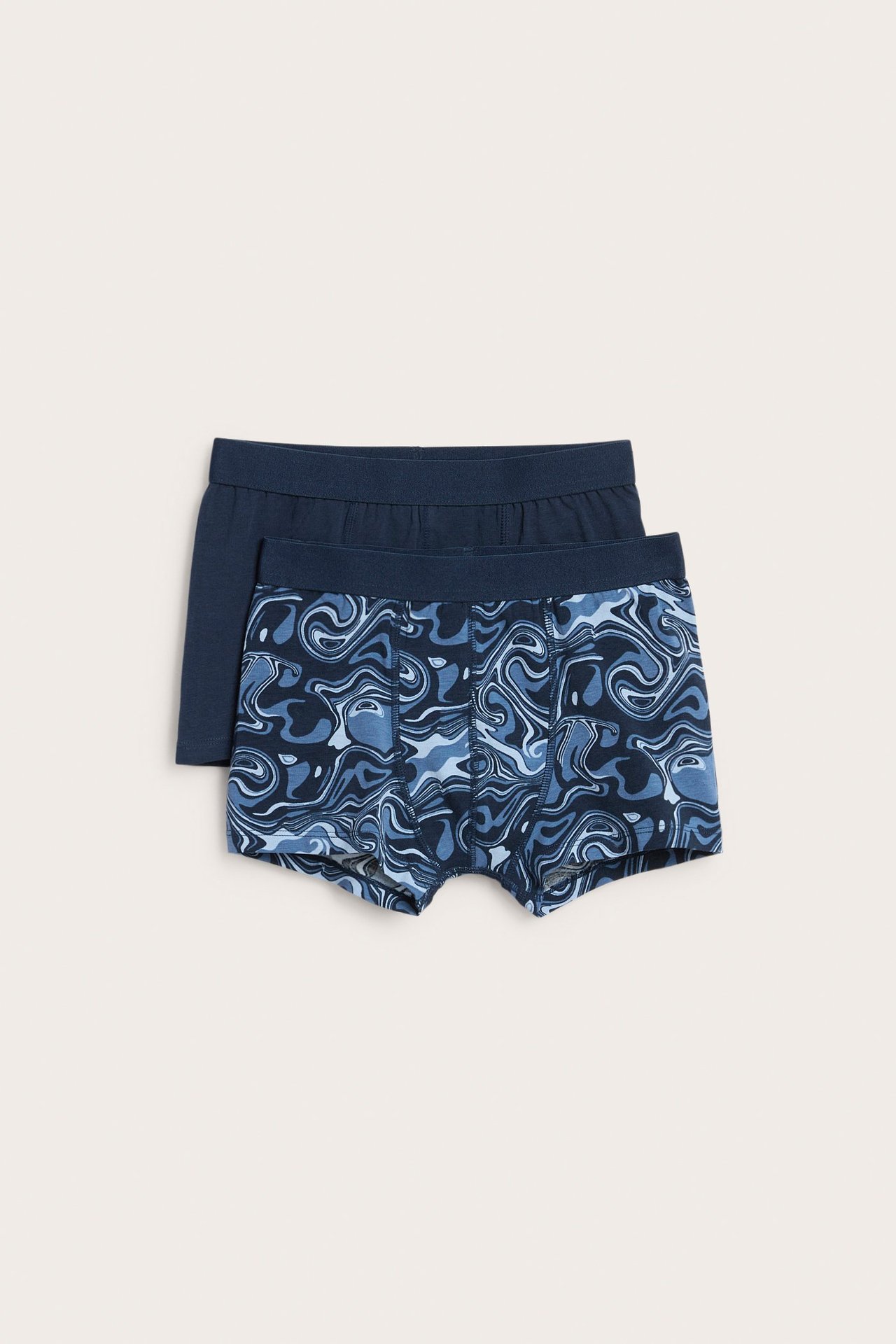 Två pack boxerkalsonger för barn, en mönstrad mörkblå och en solid mörkblå, baggy fit.