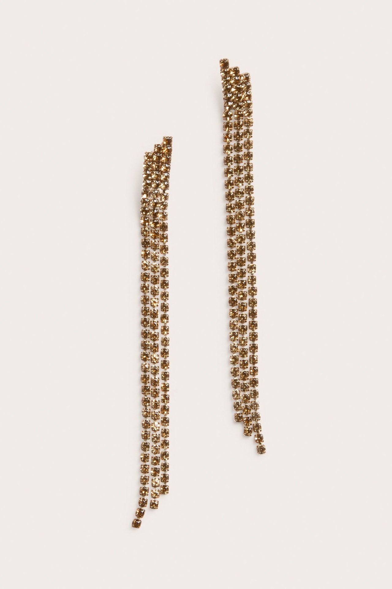 Widok z przodu długich, jasnobrązowych kolczyków z cyrkoniami, z wieloma rzędami.