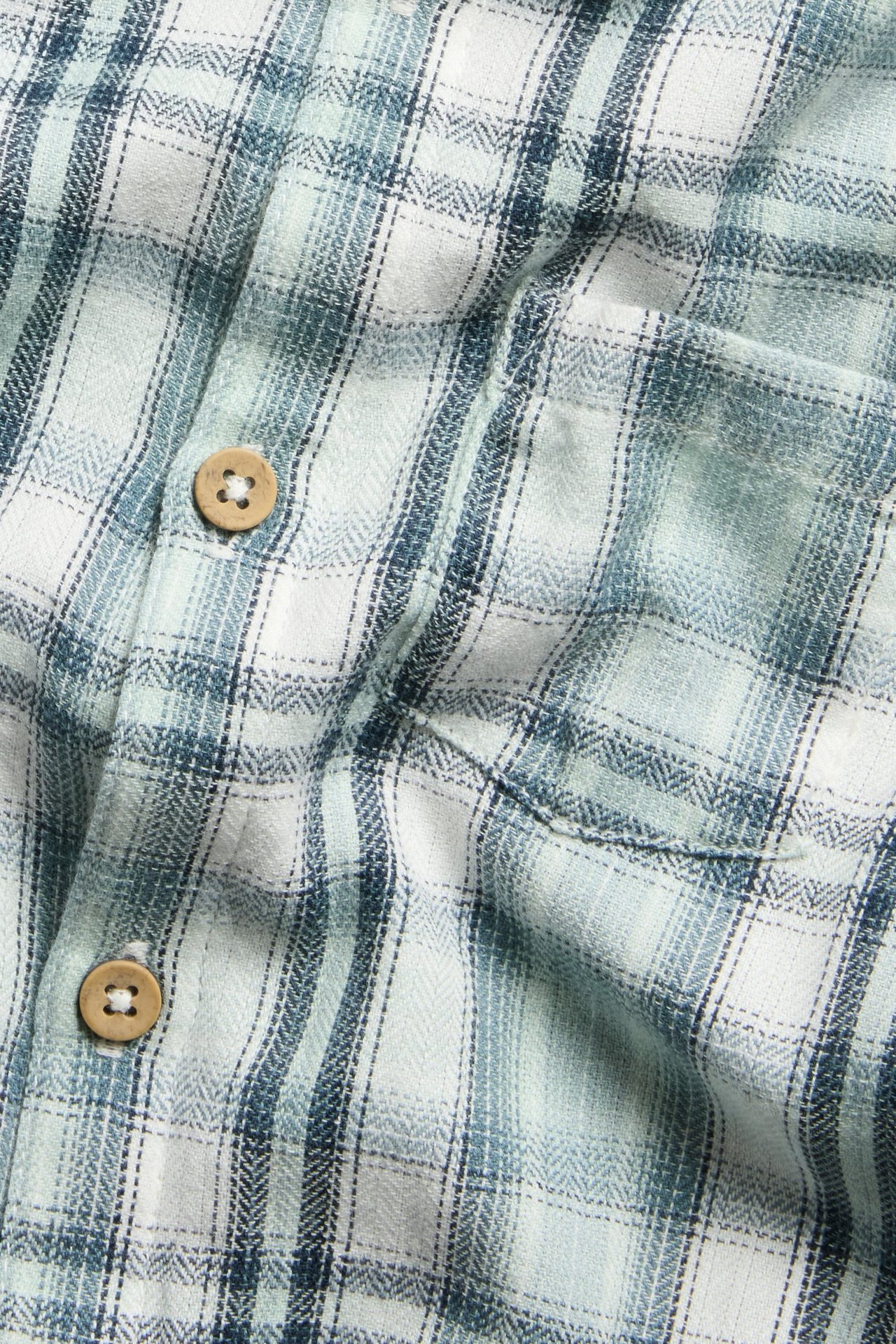 Ljusgrön rutig skjortbody för barn med krage, knäppning fram och i grenen, bröstficka.