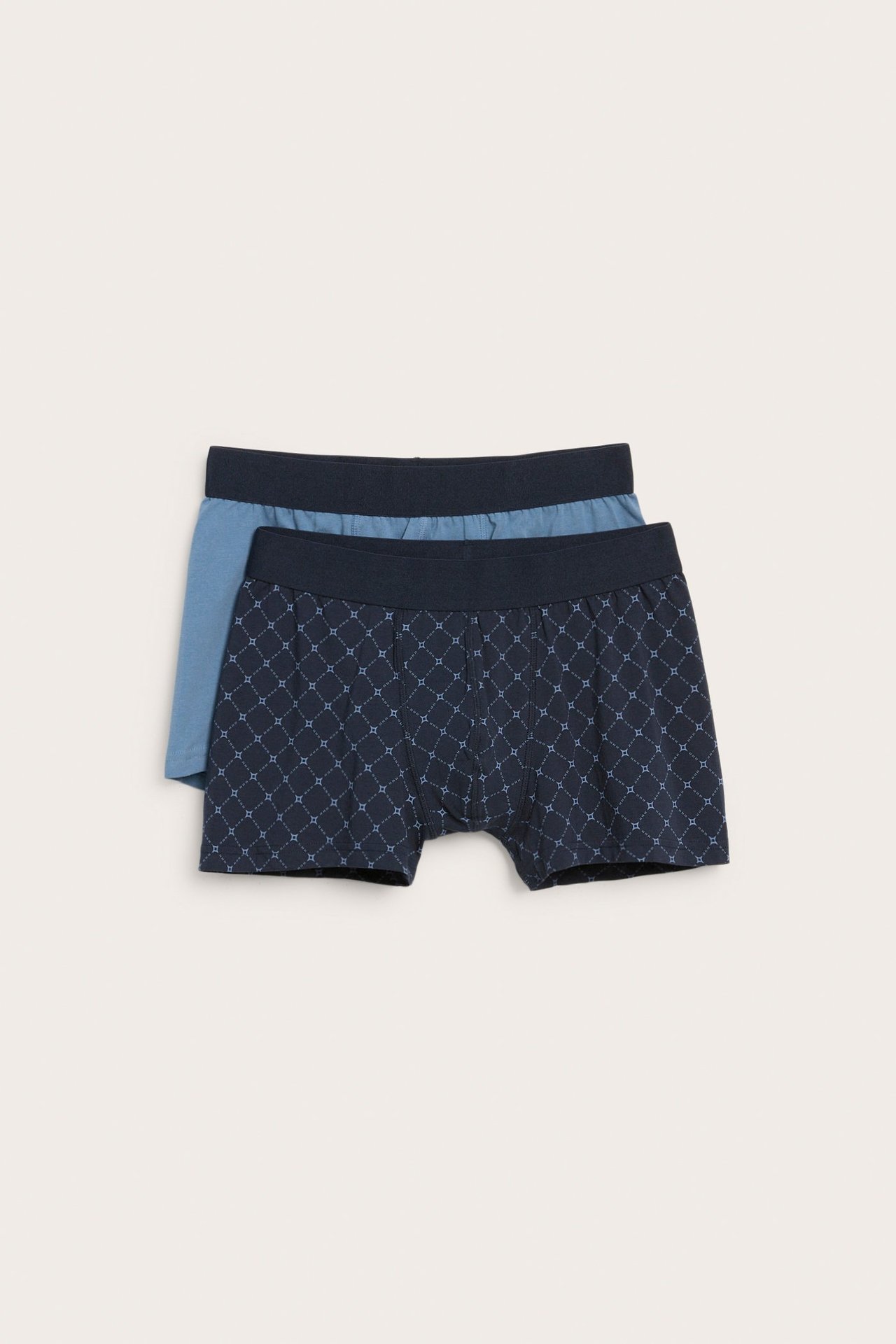 Widok z przodu męskich ciemnoniebieskich bokserek we wzory, z gładką jasnoniebieską parą z tyłu, w dwupaku.