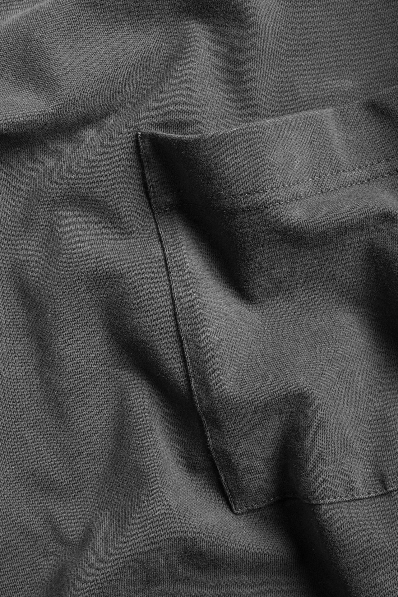 Zbliżenie na ciemnoszary melanżowy męski t-shirt z kieszenią na piersi.