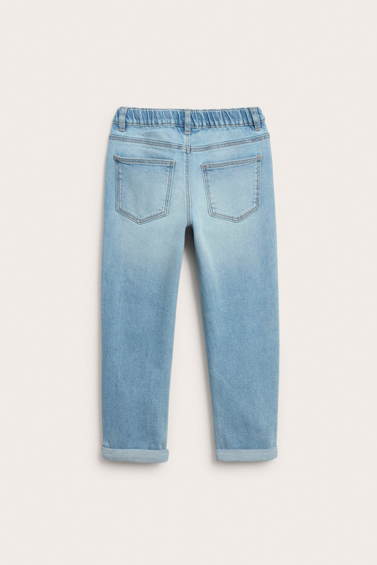 Widok z tyłu na jasnoniebieskie dżinsy o swobodnym kroju z elastycznym pasem i podwiniętymi nogawkami.
