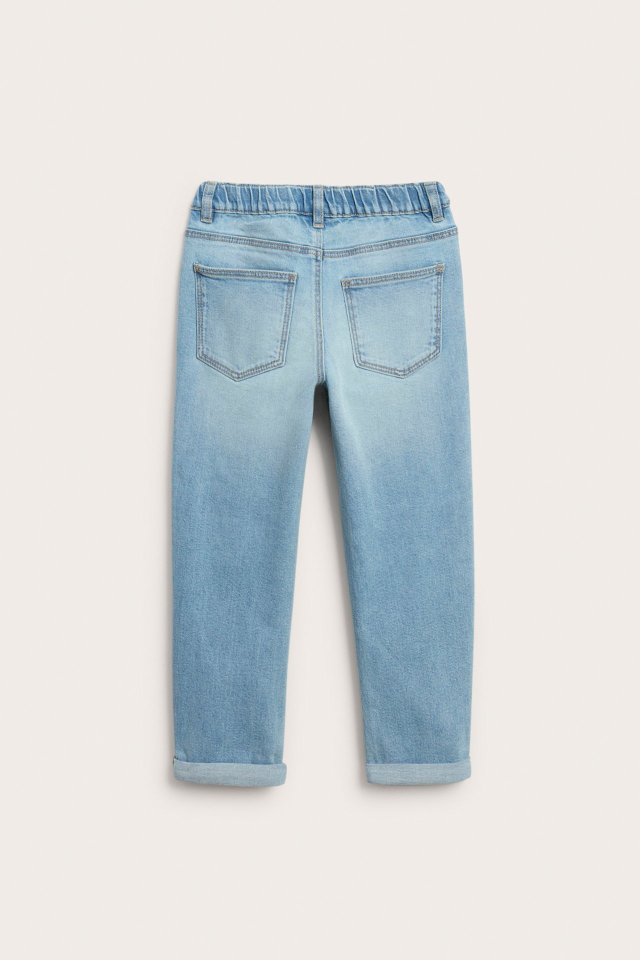 Bakfra, lyseblå barnejeans med elastisk midje og oppbrettede ben.